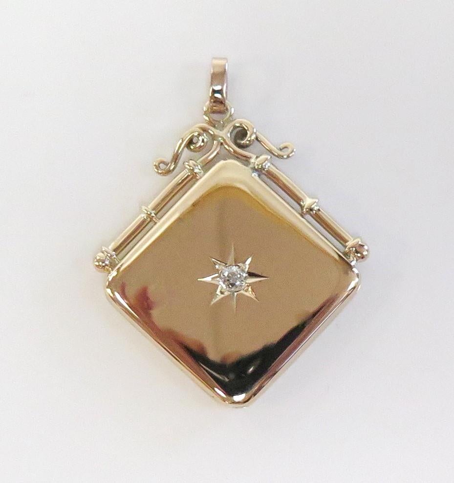This is a Victorian watch fob locket circa 1890. Square in shape, it hangs in a diamond angle from it's swirled frame and bale. In the center of the locket is an engraved starburst with an Old European Cut Diamond. One side of the locket is hinged
