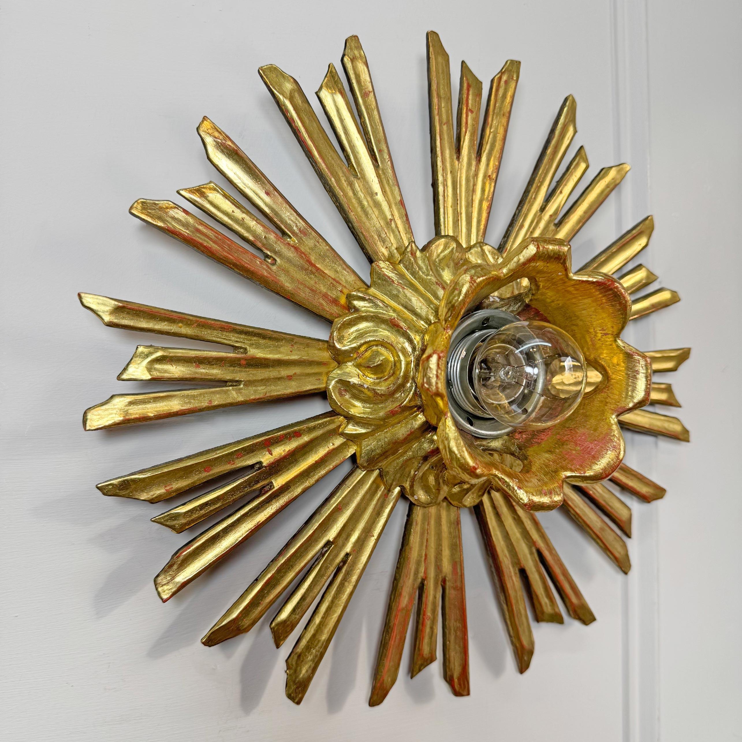 Une fabuleuse monture à encastrer en forme de soleil, dorée à l'eau, datant du 19e siècle. Des rayons en bois travaillés à la main entourent l'unique porte-lampe au centre. Originaire d'une Church's en Allemagne, cette pièce est en très bon état, la