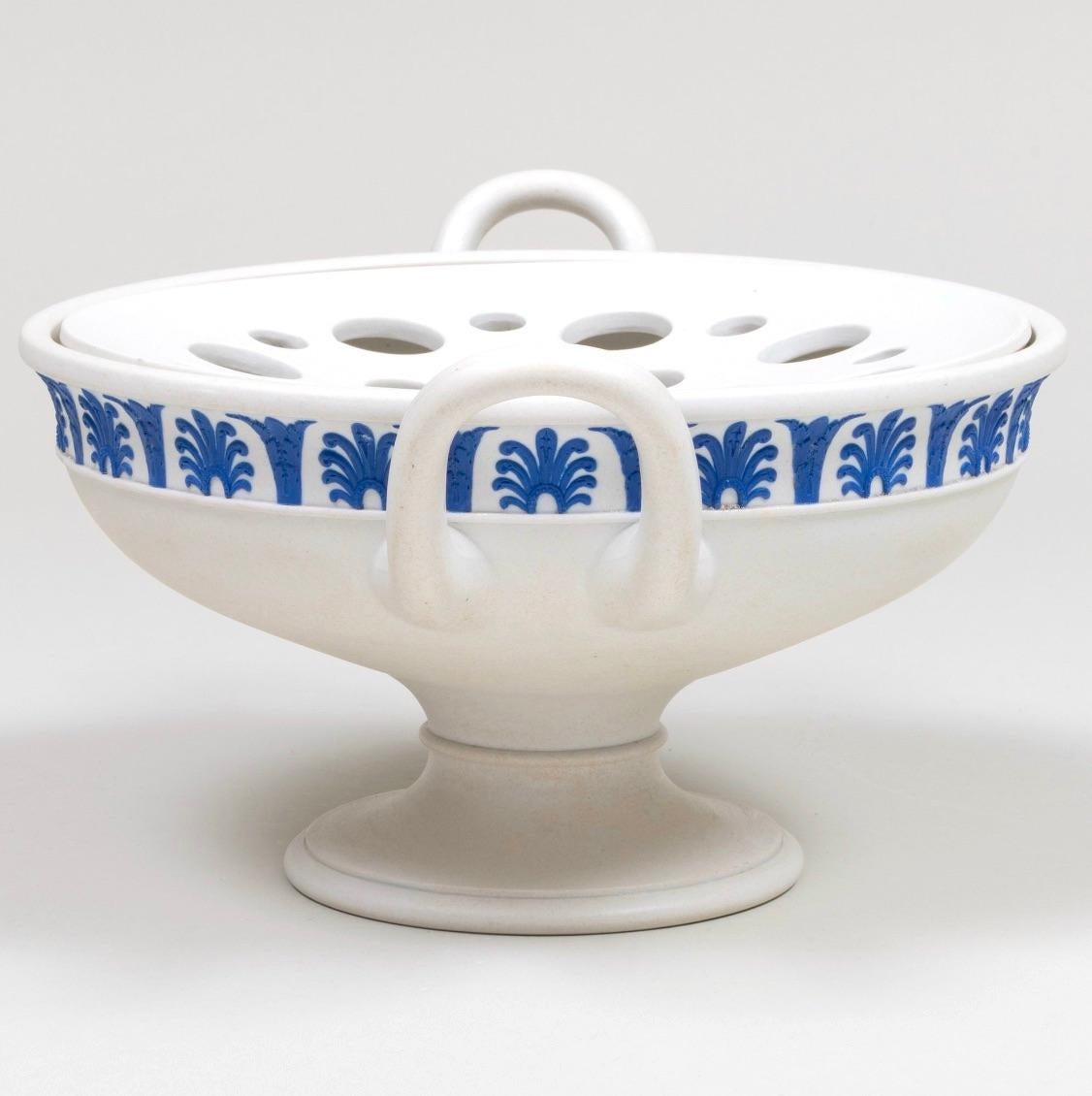 Questo squisito vaso da centrotavola Wedgwood Jasperware, risalente al 1820 circa, mostra l'eleganza e la maestria senza tempo che hanno reso Wedgwood un'icona della porcellana fine. Caratterizzato da un classico design a due pezzi, il vaso a forma