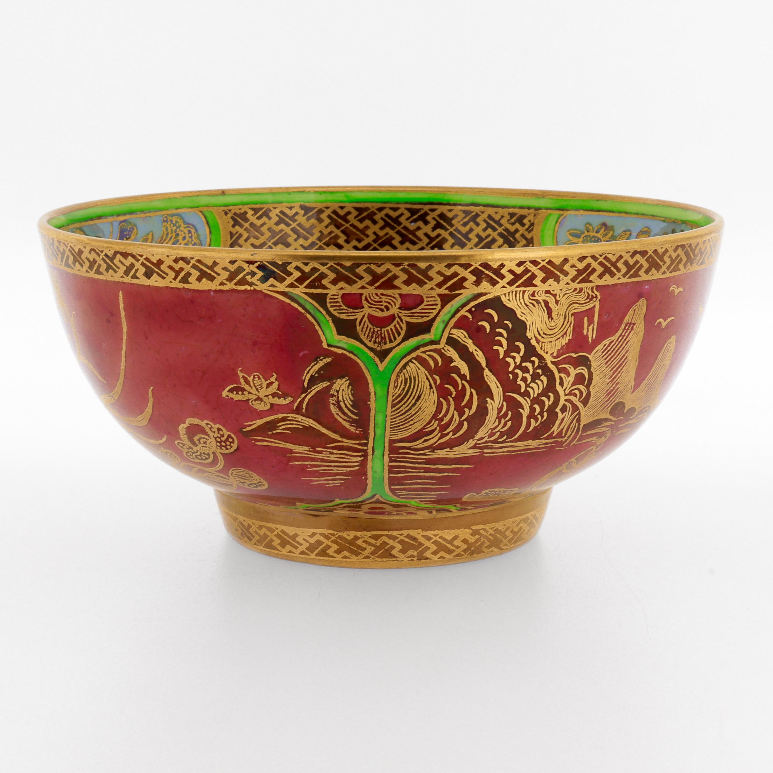 Un beau bol ancien en porcelaine lustrée anglaise.

Par Wedgwood.

Modèle no. Z5419 (intitulé Daventry).

Conçu par Daisy Makeig-Jones. 

Peint avec des motifs de Chinoiserie en or sur des tons verts, jaunes et bleus sur un fond rouge