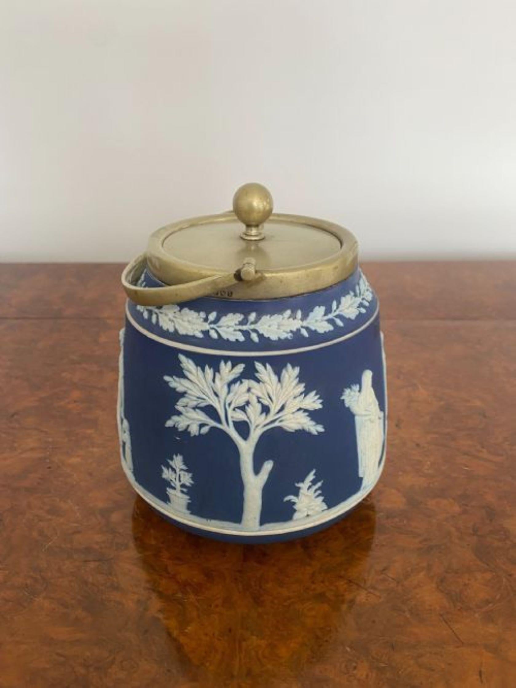 Antique Wedgwood Jasper Ware biscuit barrel decorated with classical scenes in a white cameo and blue background with a silver plated swing handle 
