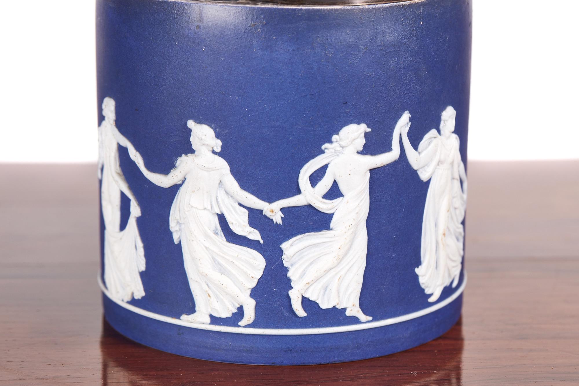 Antique wedgwood jasperware biscuit barrel, the body decorated with classical scenes in a white cameo on a blue back ground, swing silver plated handle , the base marked wedgwood
Lovely condition
Measures: 4