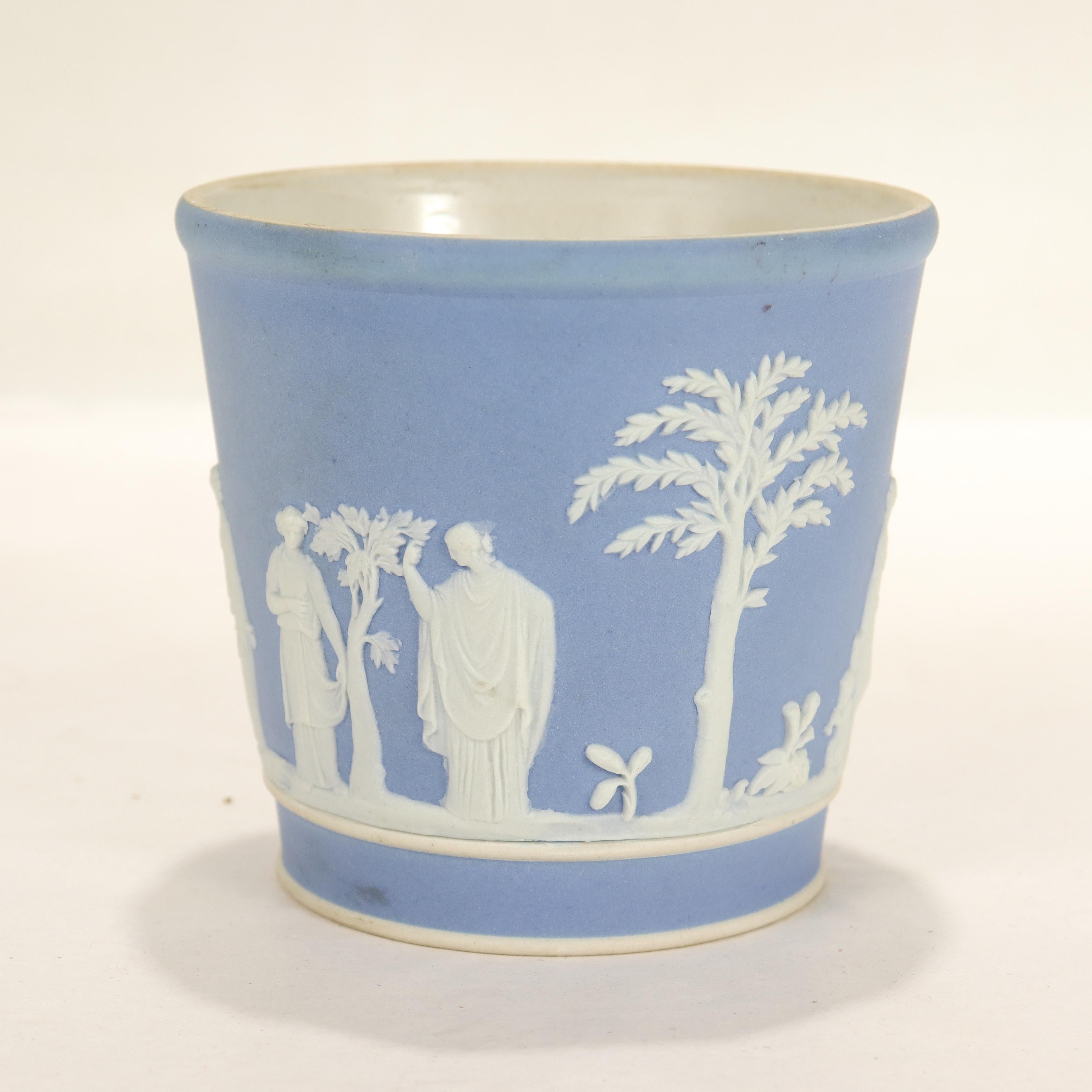 A fine antique Jasperware beaker or cup.

In Wedgwood blue with white relief decoration depicting men, women, children, and trees in a Classical style.

We assume this was used as a tumbler or drinking vessel.

Simply a wonderful Jasperware