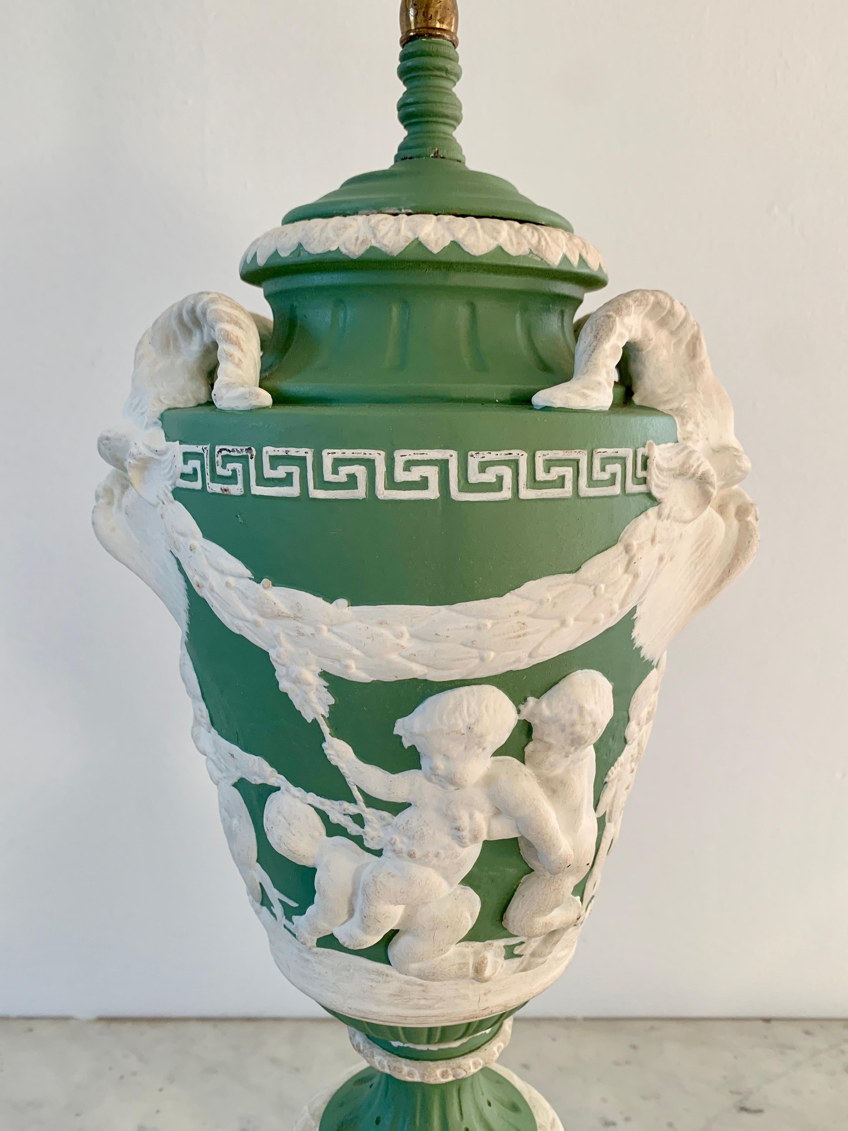 A gorgeous green & cream bisque Neoclassical style table lamp with mythological creatures, ram's horns, putti, and a Greek Key border

By Wedgwood

USA, circa 1920s

Measures: 8