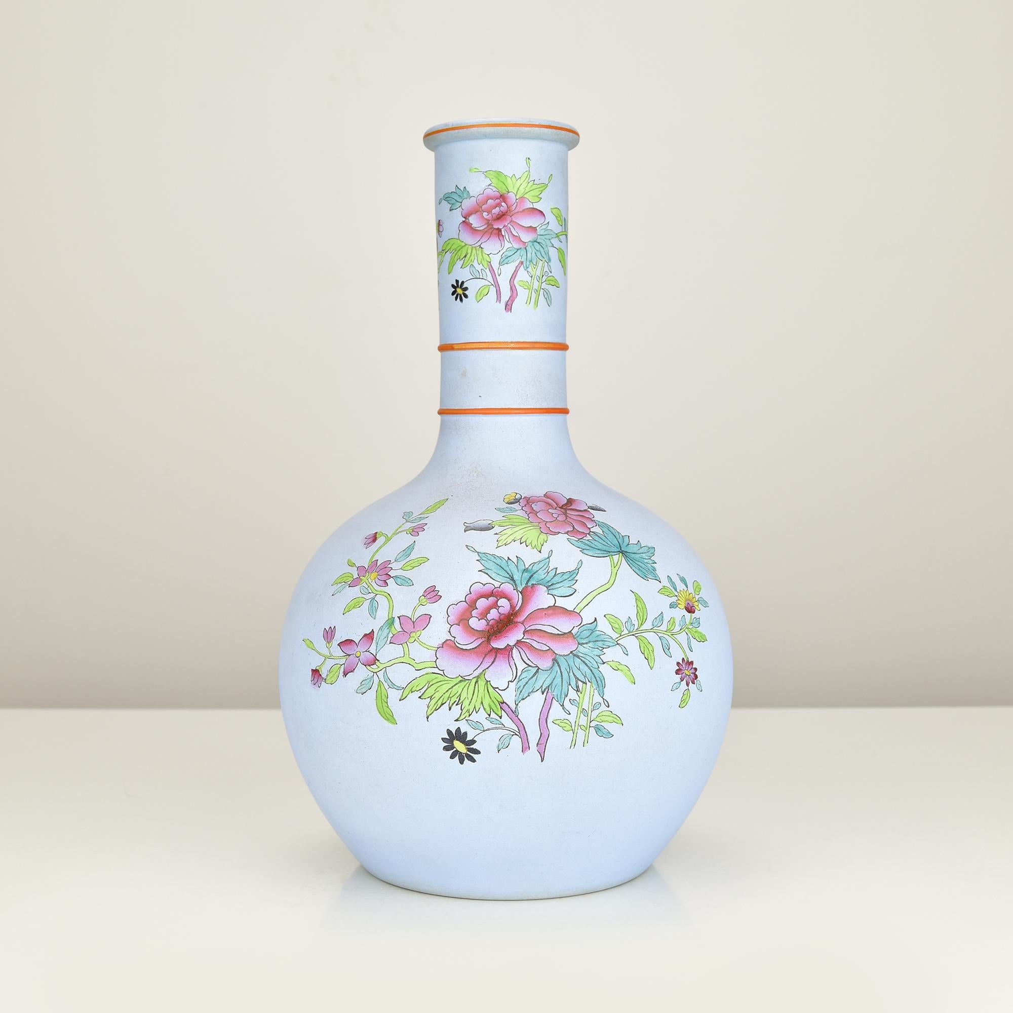 Elegante vaso a bottiglia in stile Wedgwood con una morbida finitura blu opaca, delicatamente ornato da motivi floreali dipinti a mano. I motivi floreali rosa e verdi finemente dettagliati, combinati con sottili linee d'accento arancioni,
