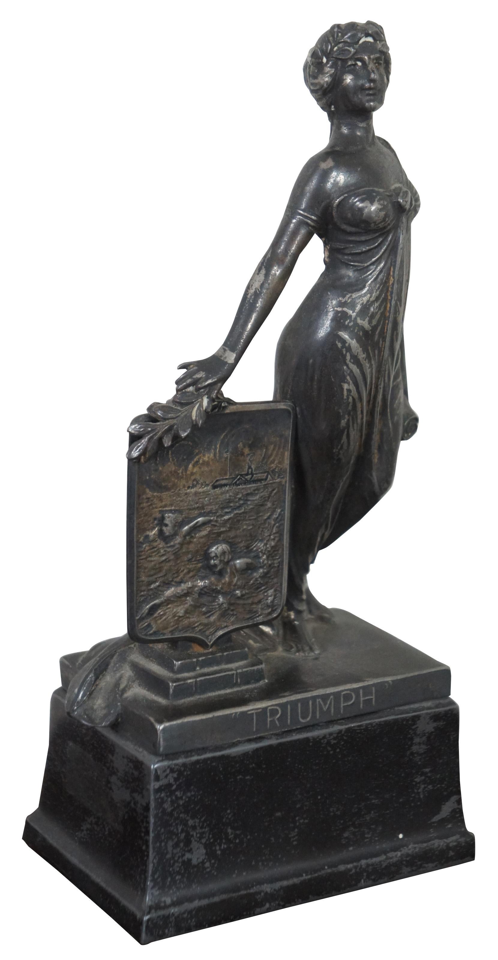 Antique cast metal trophy by Weidlich Brothers, featuring a Greek/Roman goddess style figure labeled Triumph and a shield showing a swimming scene. The plaque on the back identifies it as the “Interfraternity Swimming Trophy 1930 Won by Lambda
