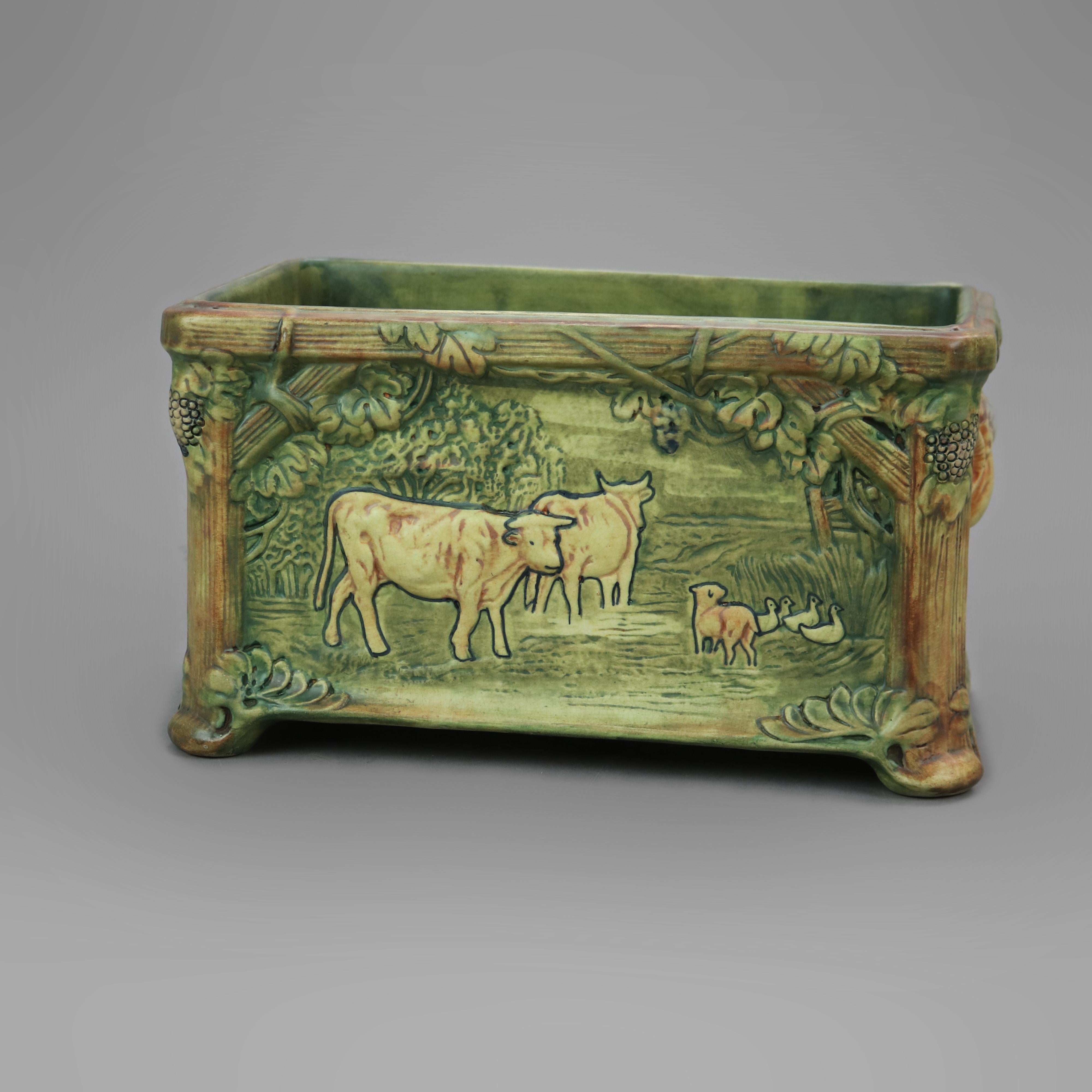 Rare antique window box jardiniere by Weller offers art pottery construction with cow in relief in countryside setting, signed on base as photographed, c1930

Measures - 7'' H x 12.25'' W x 7.25'' D.