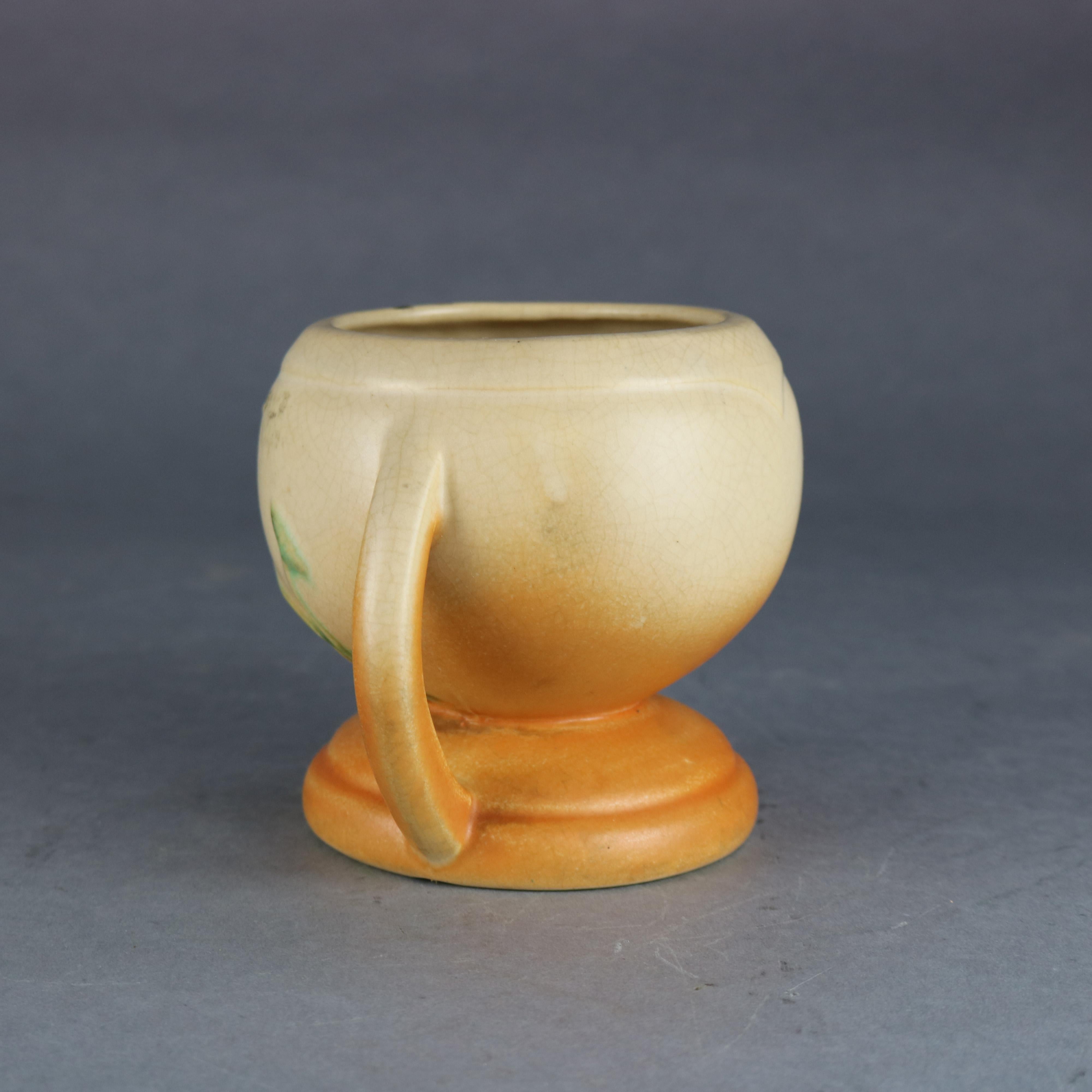 An antique art pottery vase by Weller Pottery features double handled bulbous body and double handled having nasturtium flower decoration and seated on footed base, maker signed and numbered as photographed, circa 1930.

Measures: 4.75
