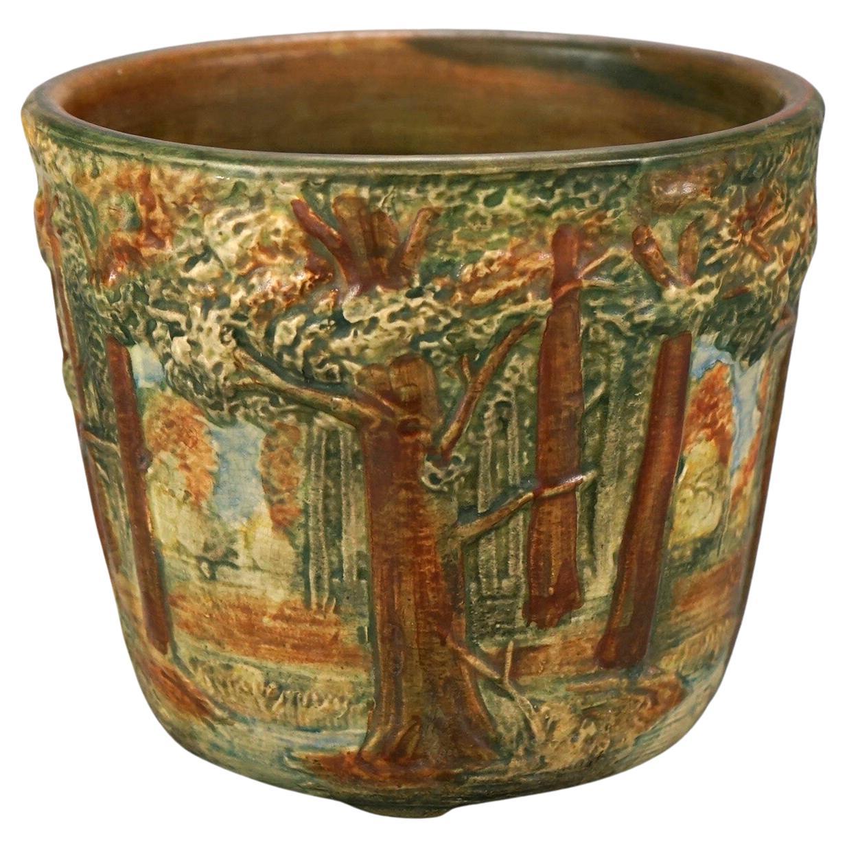 An antique art pottery jardiniere planter by Weller offers forest scene in relief, maker stamp on base as photographed, c1930

Measures- 6.75''H x 8.25''W x 8.25''D.

Catalogue Note: Ask about DISCOUNTED DELIVERY RATES available to most regions