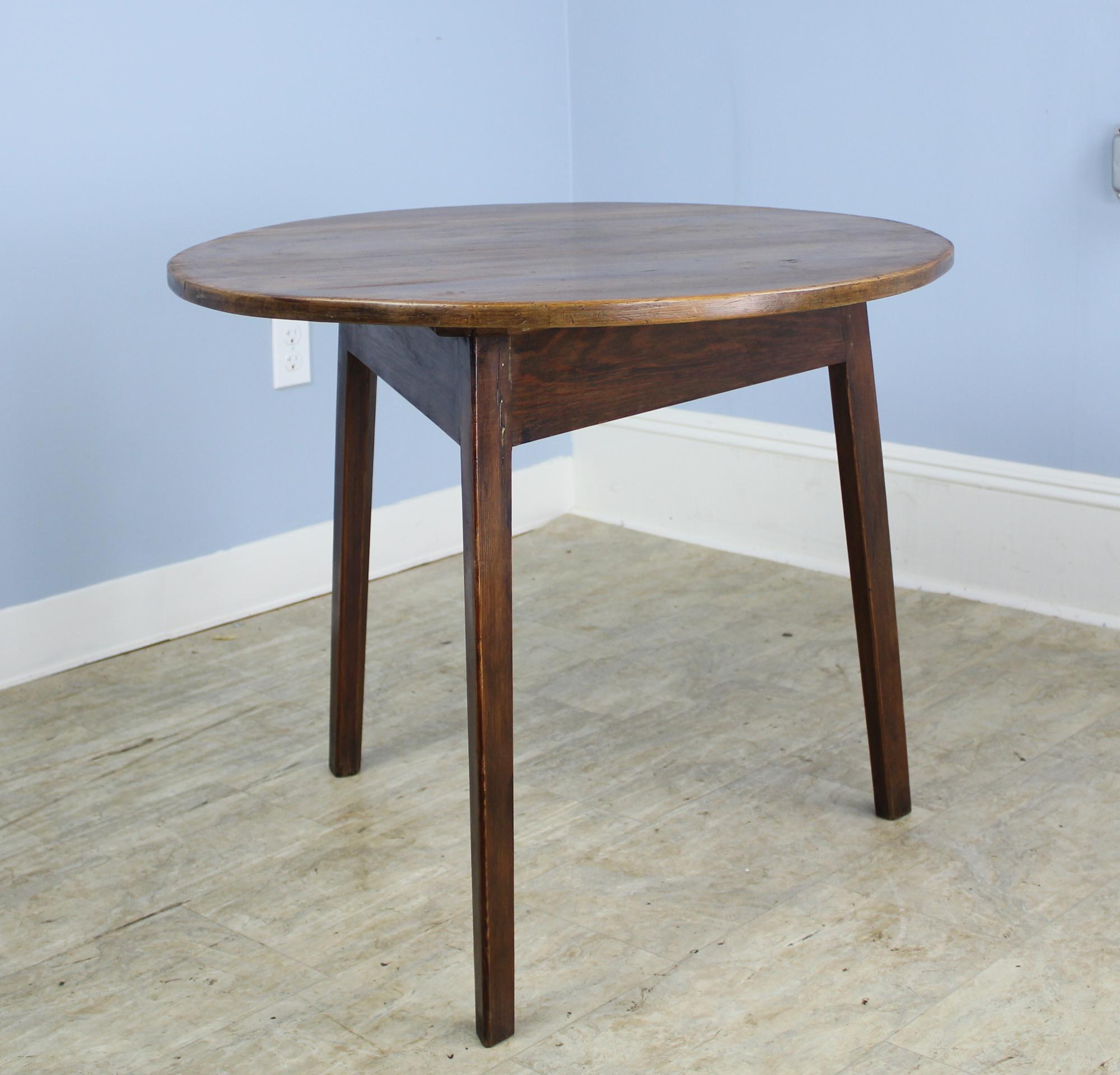 A pretty cricket table with suitable height for use as a good side, lamp or occasional table. The fruitwood top has rich color and god patina. Traditional tripod base construction. A simple versatile Silhouette.