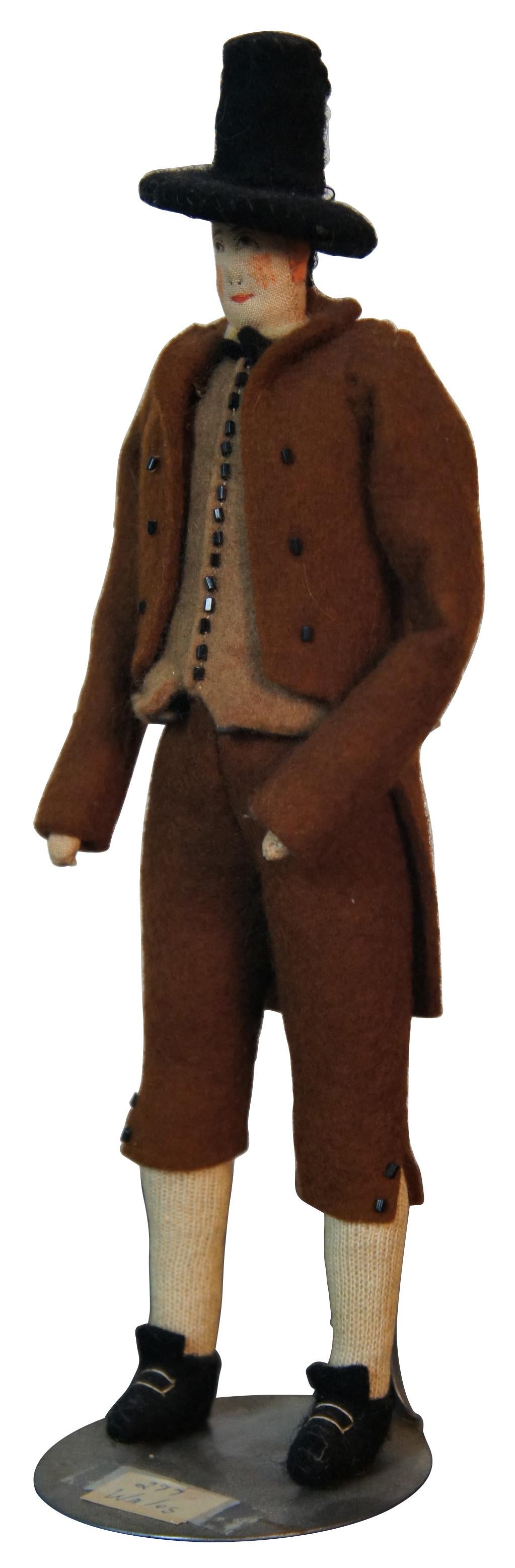 Antique Welsh costume cloth doll of a man in a brown formal tux style suit, reminiscent of 17th century Pilgrims, with delicately painted face and wool clothing; made in Wales. Measures: 10