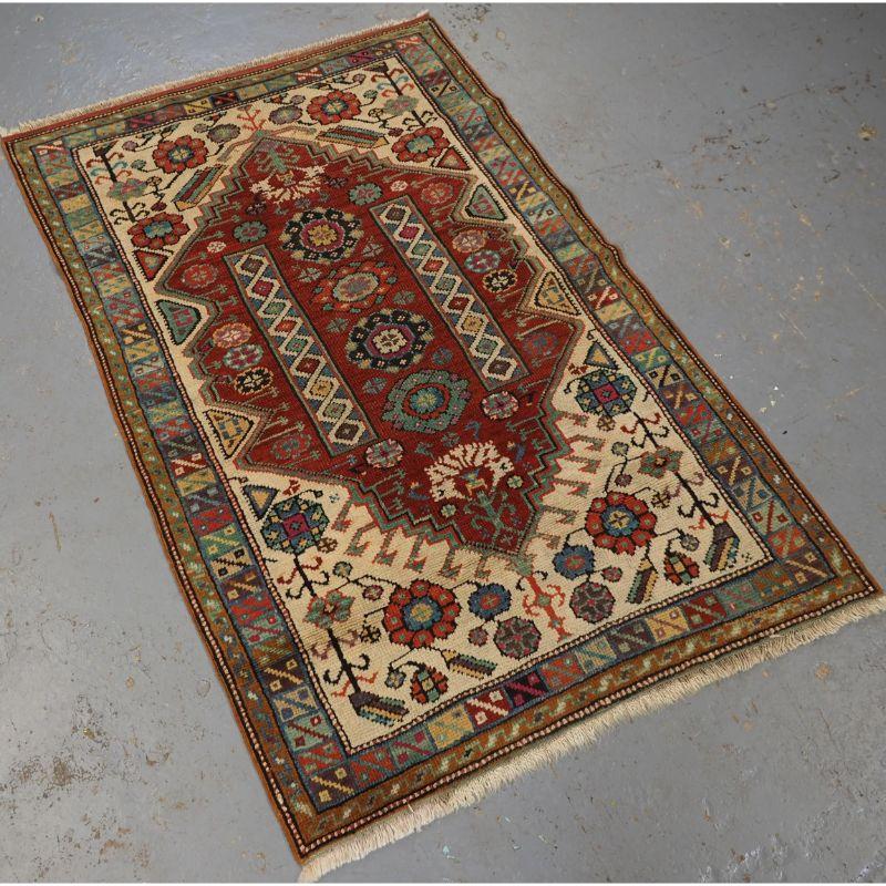 Antique west Anatolian rug from the village of Mihalicik in the region close to Eskisehir and Ankara.

The rug has a very rich red ground colour to the central field, there is a large carnation flower at each end of the field along with two central