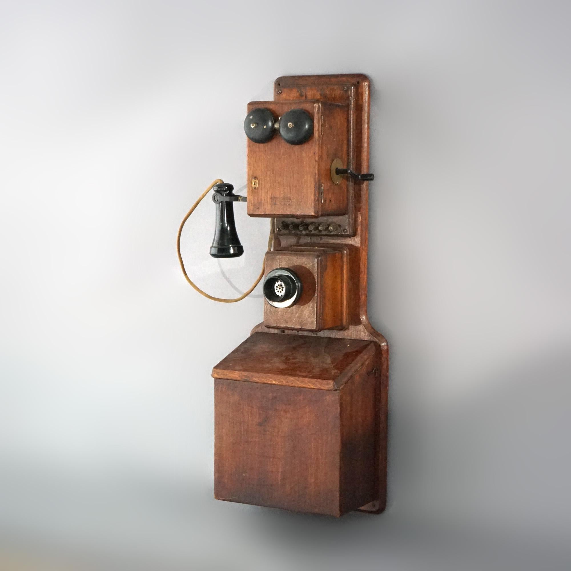 An antique western electric wall telephone offers full body oak case with hand crank; rewired to work with newer phone line, c 1900.

Measures:  32.5'' H x 11.75'' W x 7.25'' D.