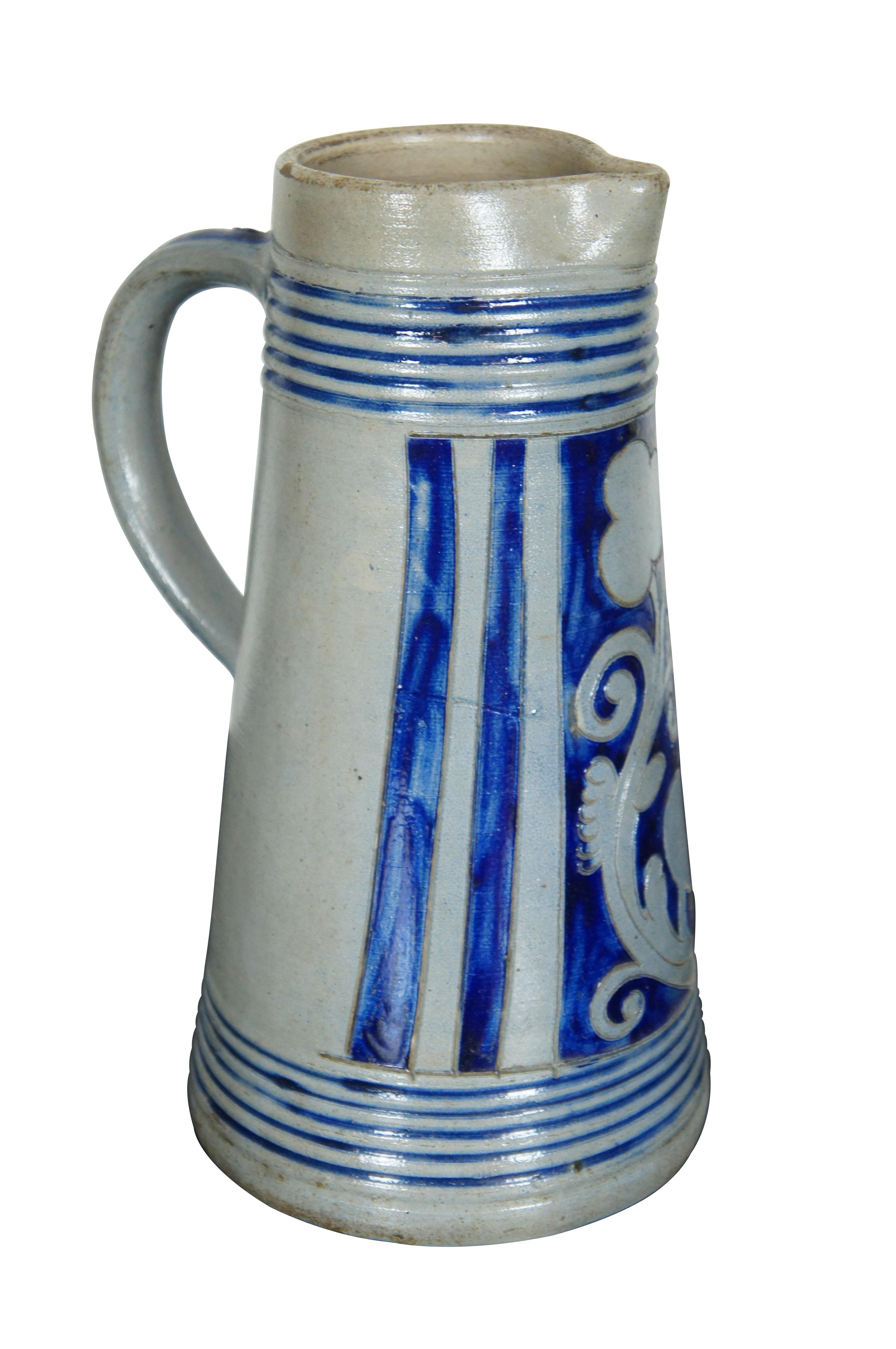 Antique German Westerwald stoneware pottery decanter jug or pitcher.  

Westerwald pottery, or Westerwald stoneware, is a distinctive type of salt glazed grey pottery from the Höhr-Grenzhausen and Ransbach-Baumbach area of Westerwaldkreis in