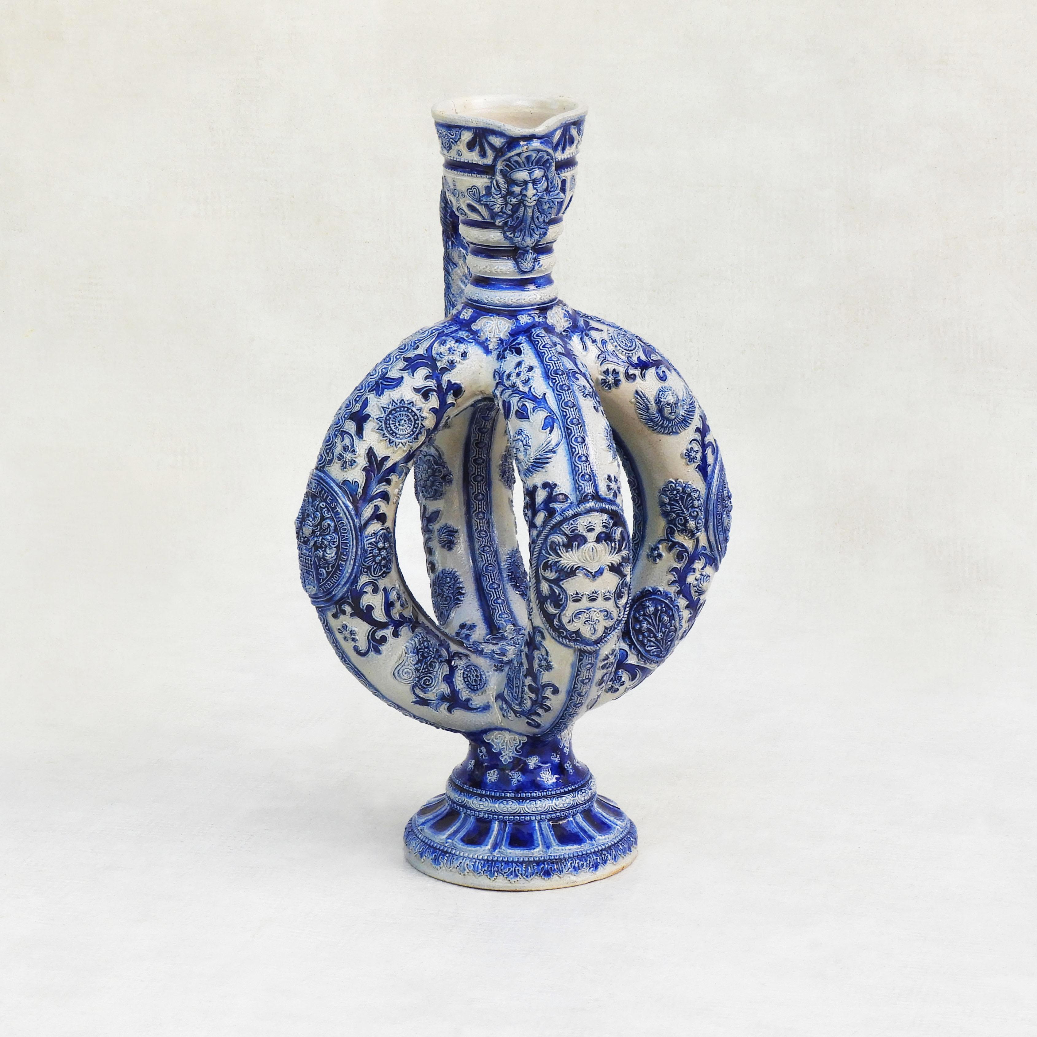 Antique Westerwald stoneware Ewer C1900

A rare German Westerwald salt glazed pottery ewer c1900.
An elaborately decorated stoneware jug with a tall ribbed neck and two intersecting double rings, beautifully embellished in deep cobalt blue with