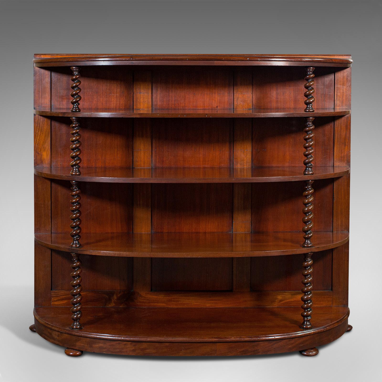 This is an antique boat-tail whatnot bookshelf. An English, mahogany demi-lune bookcase cabinet, dating to the mid Victorian period, circa 1860.

Dashing bow-front form enhanced with delightful colour
Displaying a desirable aged patina