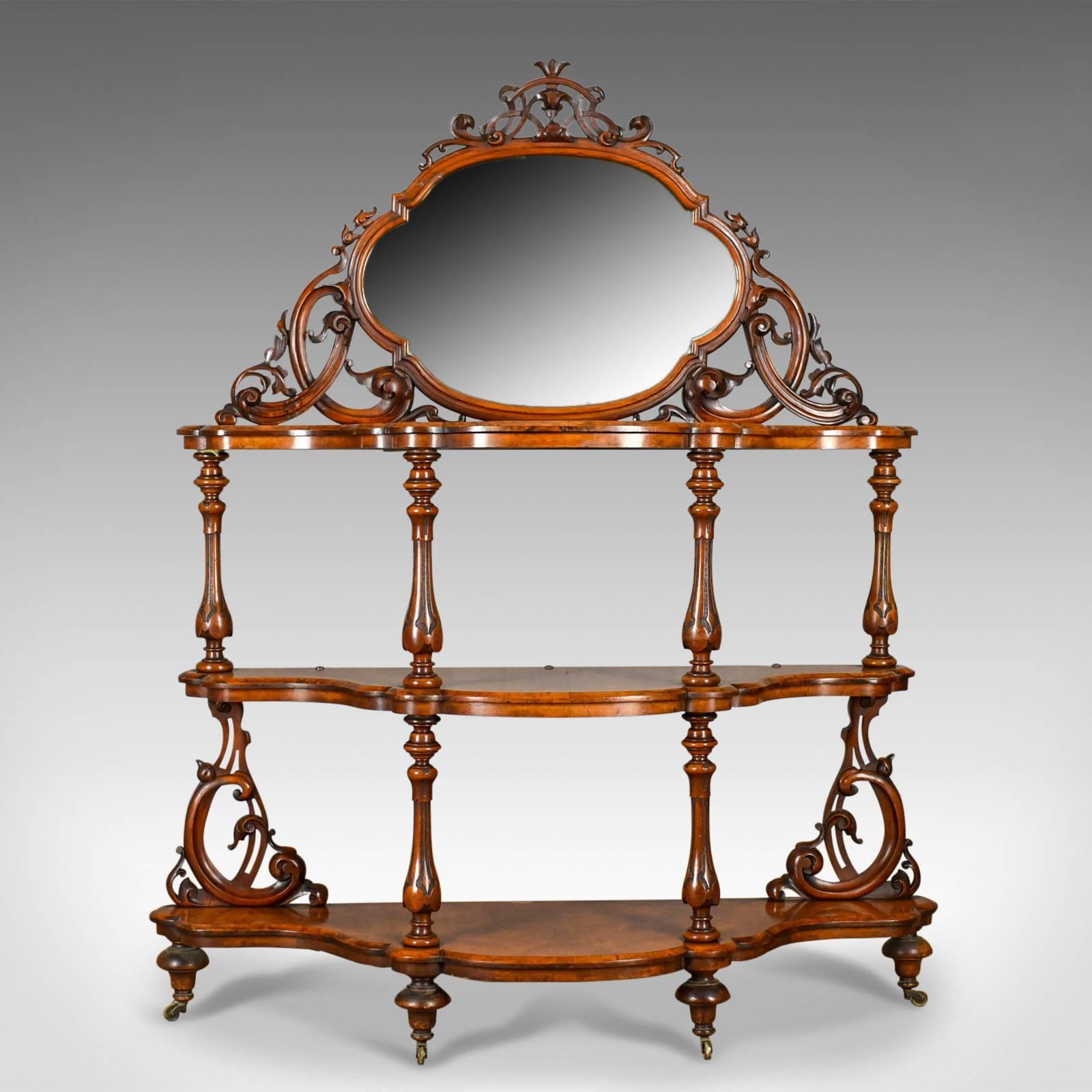 This is an antique whatnot, an Irish, burr walnut, three tier, mirror-back, display Stand by the highly regarded Robert Strahan & Co. firm of Dublin, Ireland. Dating to the early to mid-19th century, circa 1840.

Of exceptional quality befitting