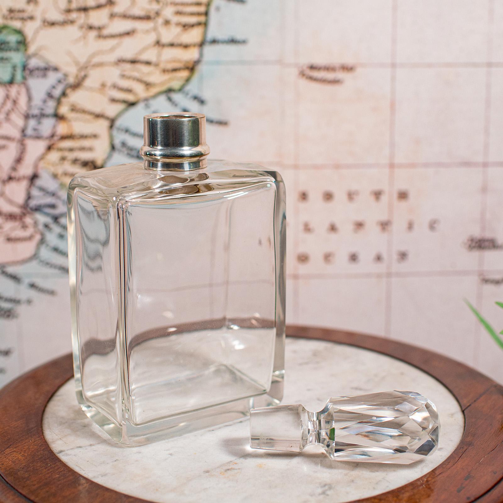 This is an antique whiskey decanter. An English, glass spirit bottle with silver collar, dating to the early 20th century and hallmarked in 1921. An appealing example with charming form and a quality silver mount.

Attractive early 20th century