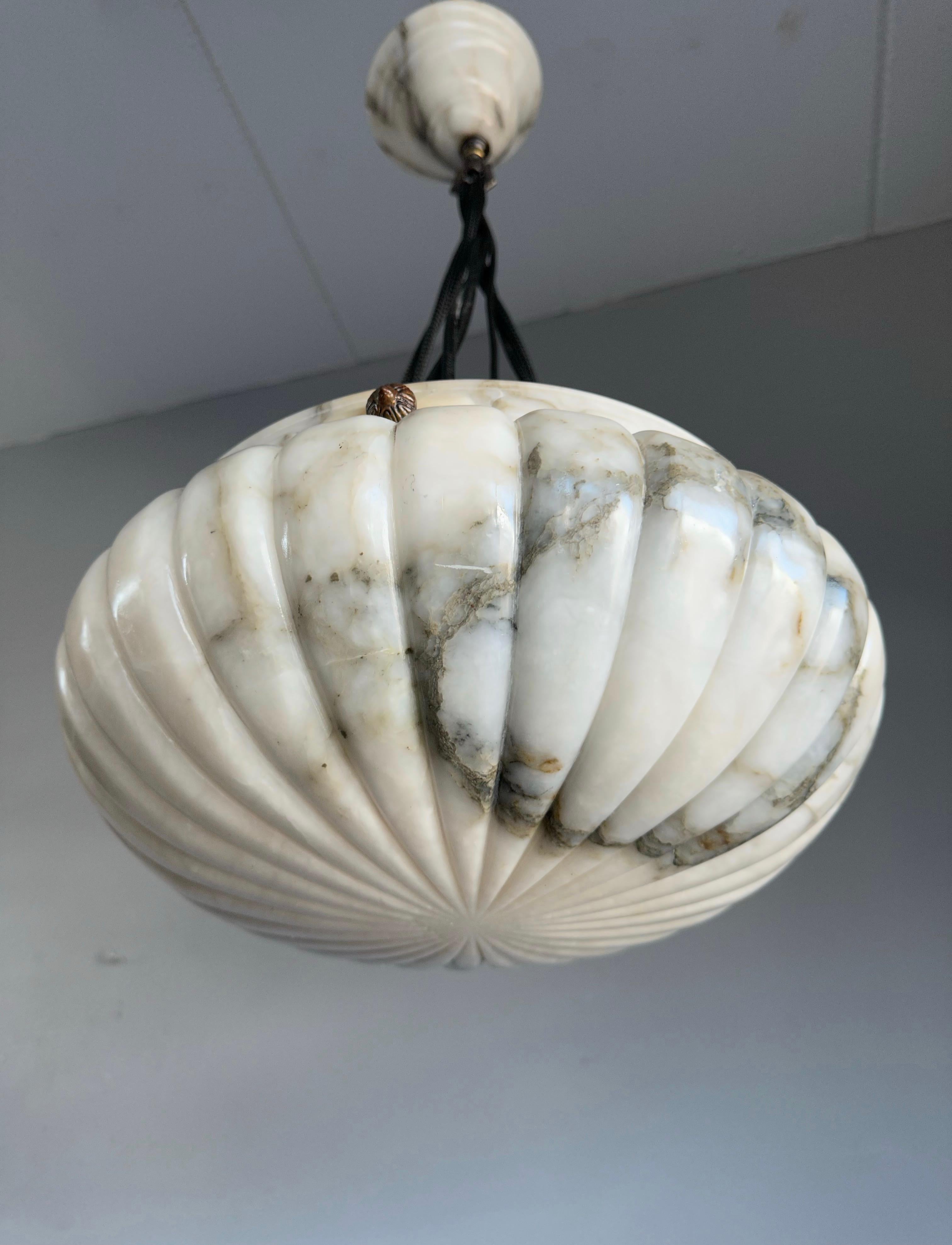 Top class light fixture with a stunning, deeply hand carved, alabaster plafonnier shade.

Thanks to its unique design, its good size, and its truly excellent condition this alabaster chandelier will light up both your days and evenings. Apart from