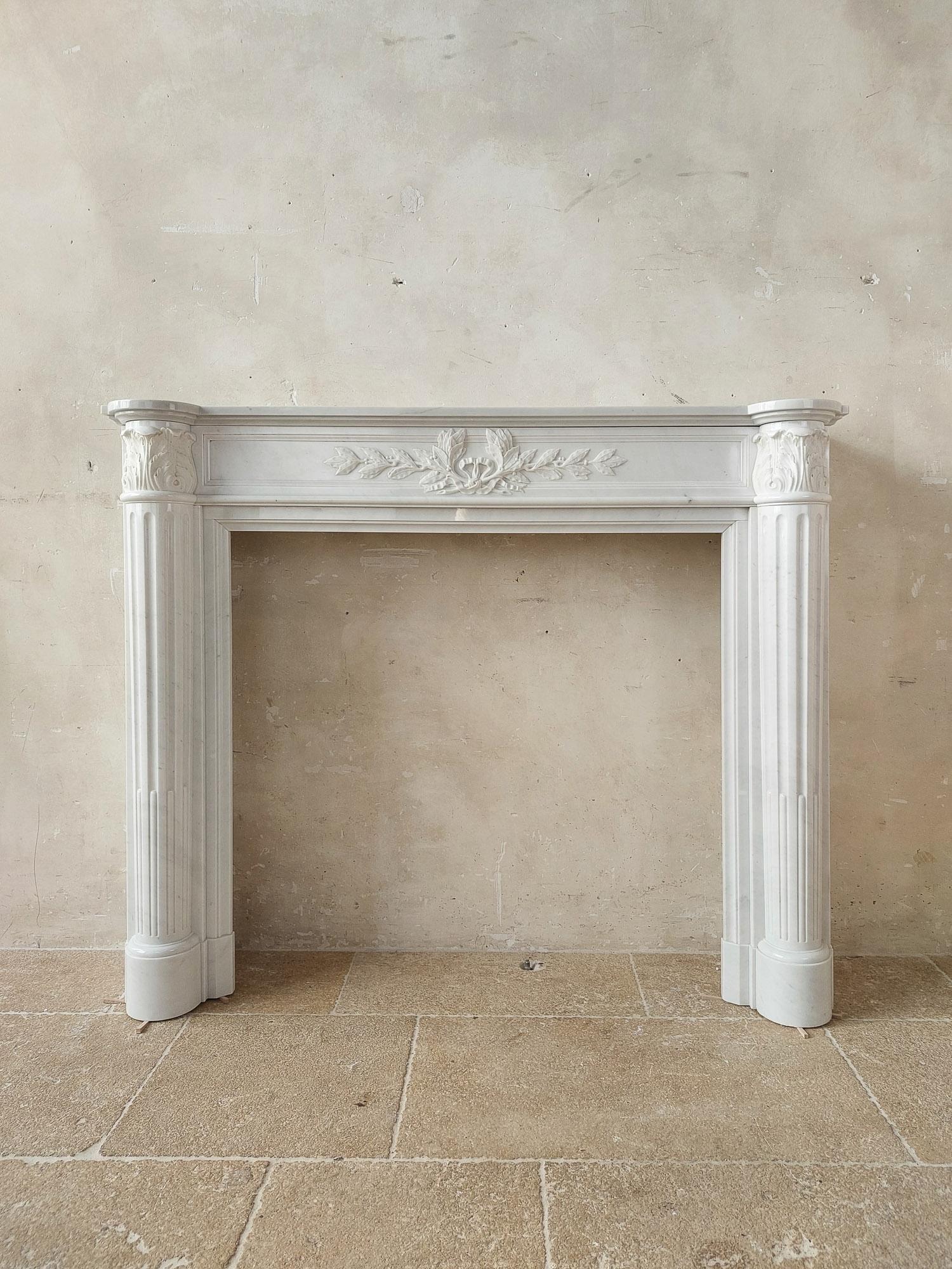 Antique Carrara marble Louis Seize mantle piece from the 19th century. Louis XVI style fireplace in white marble with finely carved laurel and acanthus decorations and fluted jambs.

Dimensions: H 119 x w 133 x d 33 cm
Marble inner dimensions: H