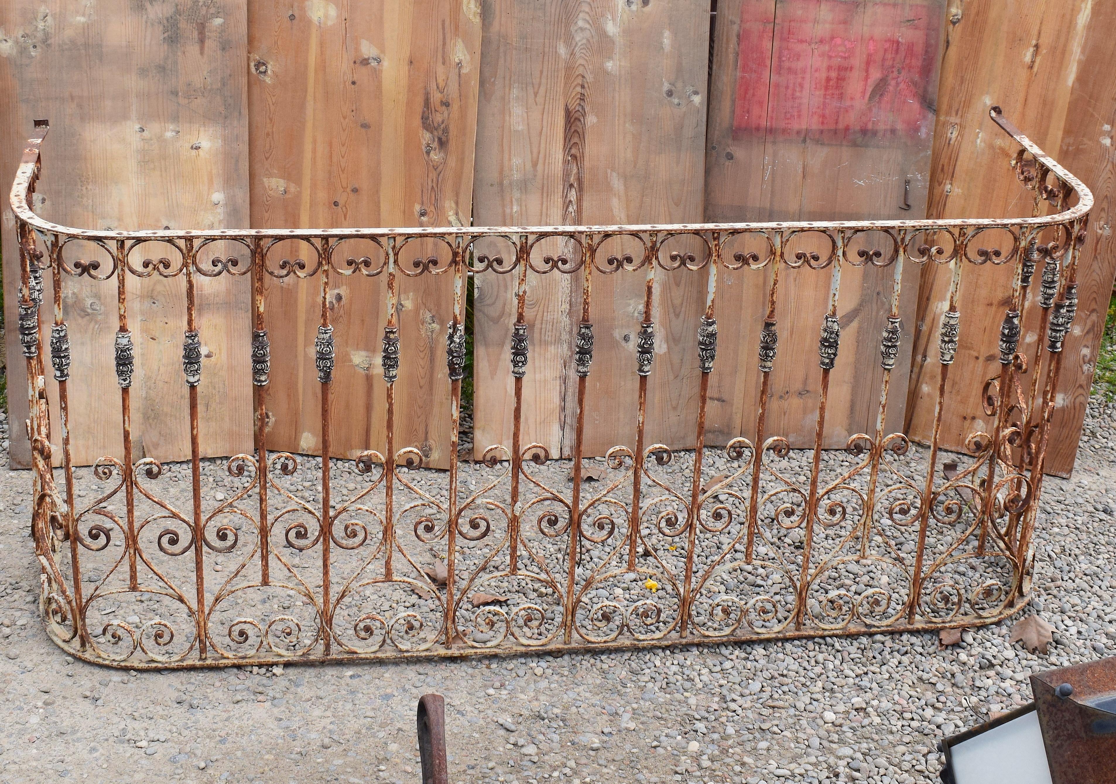 19th century French fence railing from a balcony section constructed from wrought iron. It is beautifully handcrafted with twisted, scrolled decoration and heart motifs. The iron still retains much of the old lacquer finish in layers of white and