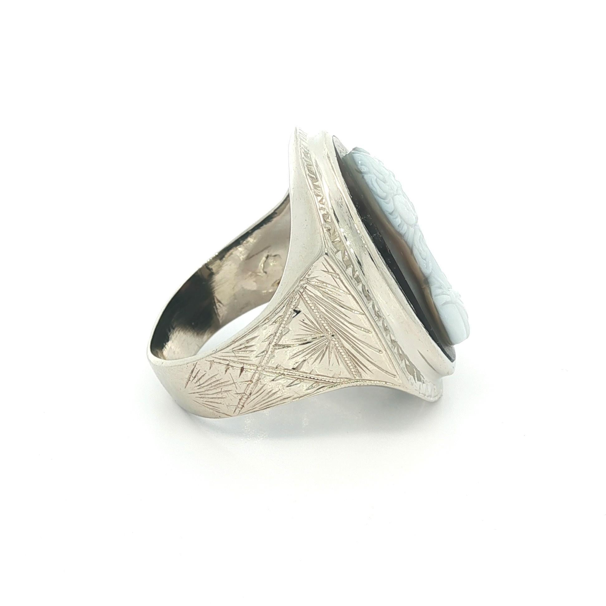 -Piedra(s): -
(1) Piedra dura natural auténtica - Talla ovalada - Bisel engastado - Color base negro con tallas blancas - 21,7 x 15,82 mm (aprox.)

Material: Oro blanco macizo de 14 quilates
Peso total:  11,44 gramos
Anchura total: 25,91 mm (1,02