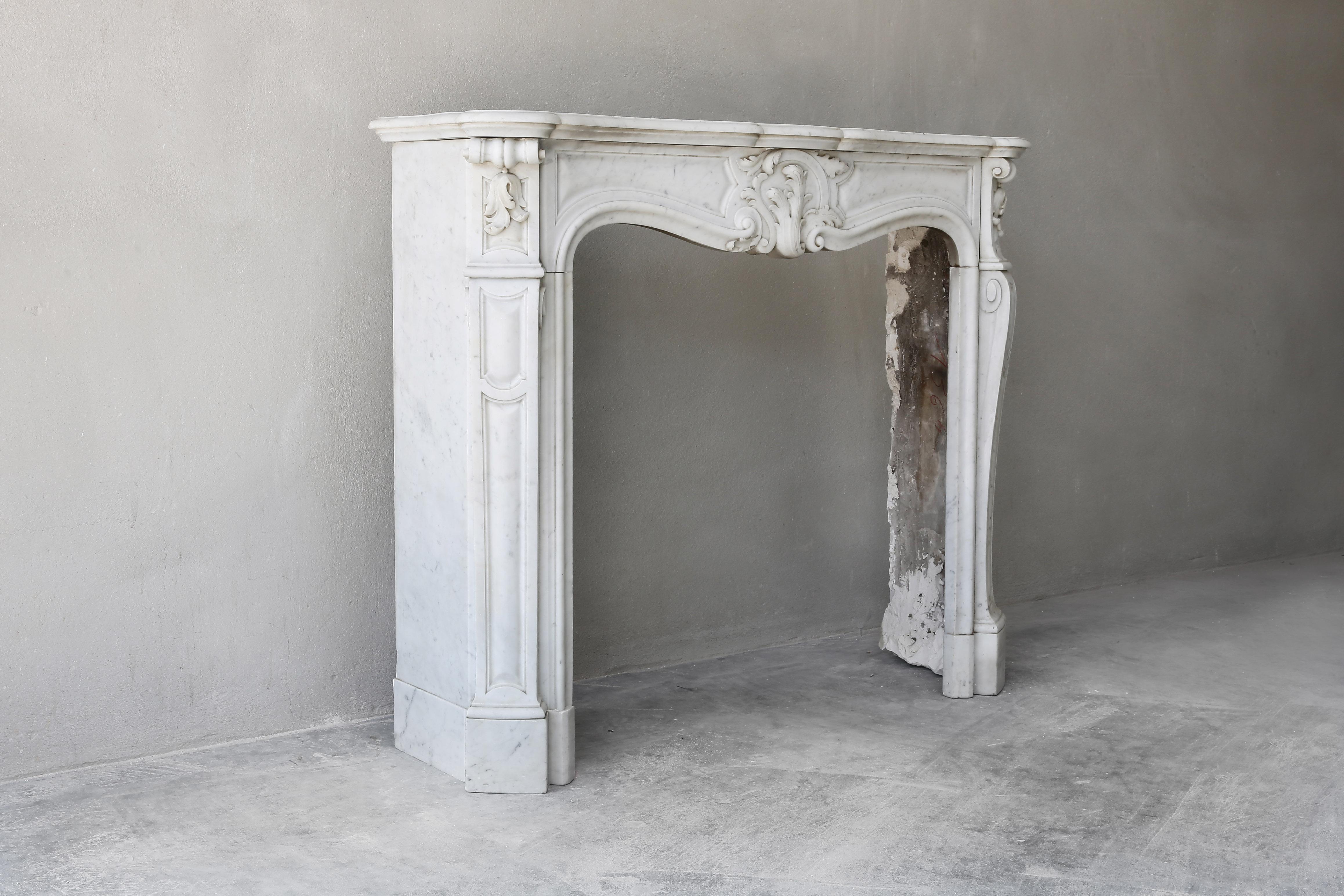 Beautiful antique fireplace of white marble. This marble type is Carrara and comes from Italy. We have various antique mantelpieces of Carrara marble in stock in our warehouse. The chimney is in the recognizable style of Louis XV and dates back to