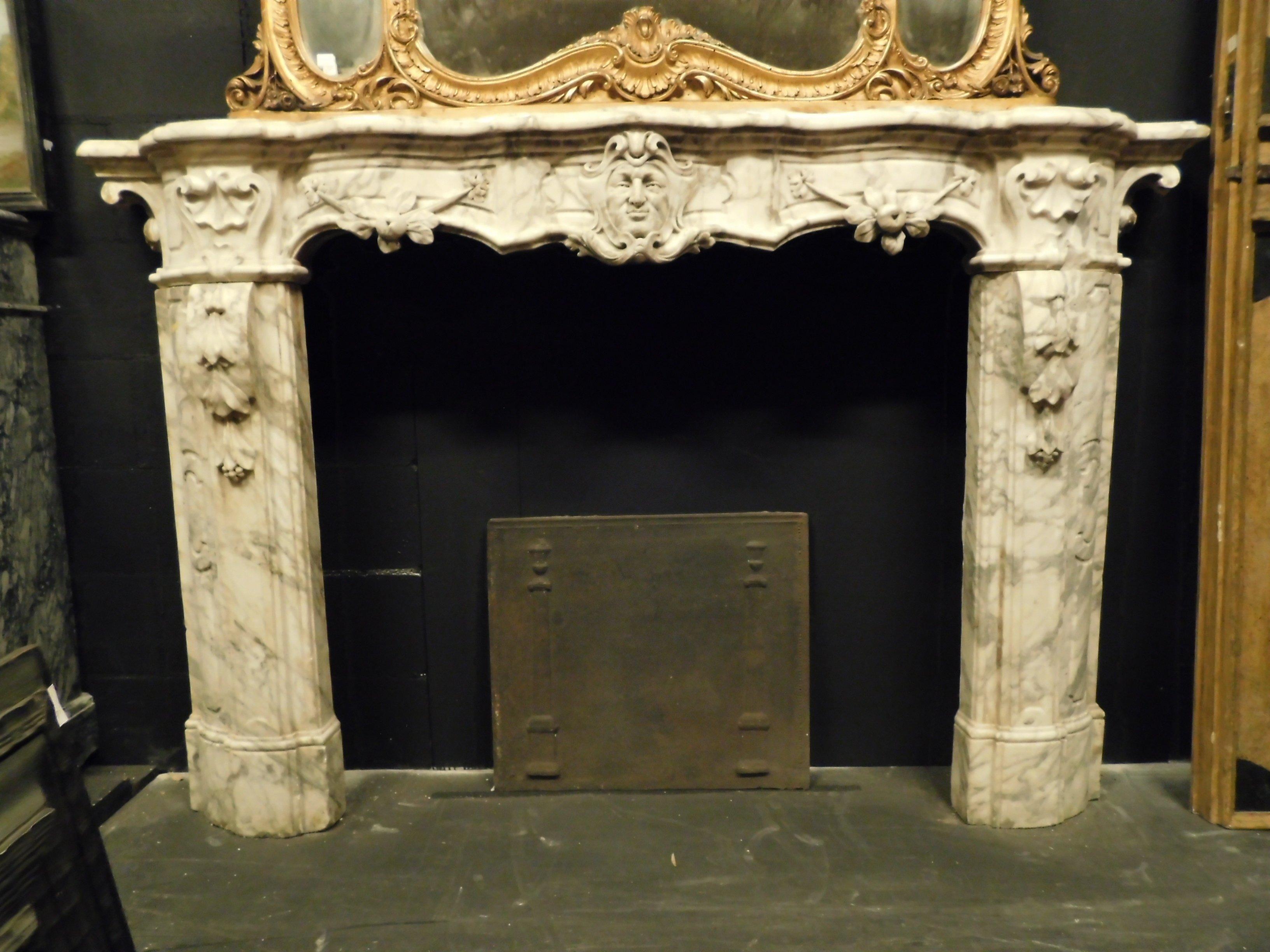 Ancient Italian fireplace in white Carrara marble but veined gray, with carved mask and friezes on the uprights, very rich and with many moves, from movement to the room and heat, beautiful marble patina and the value of the sculpture makes it an