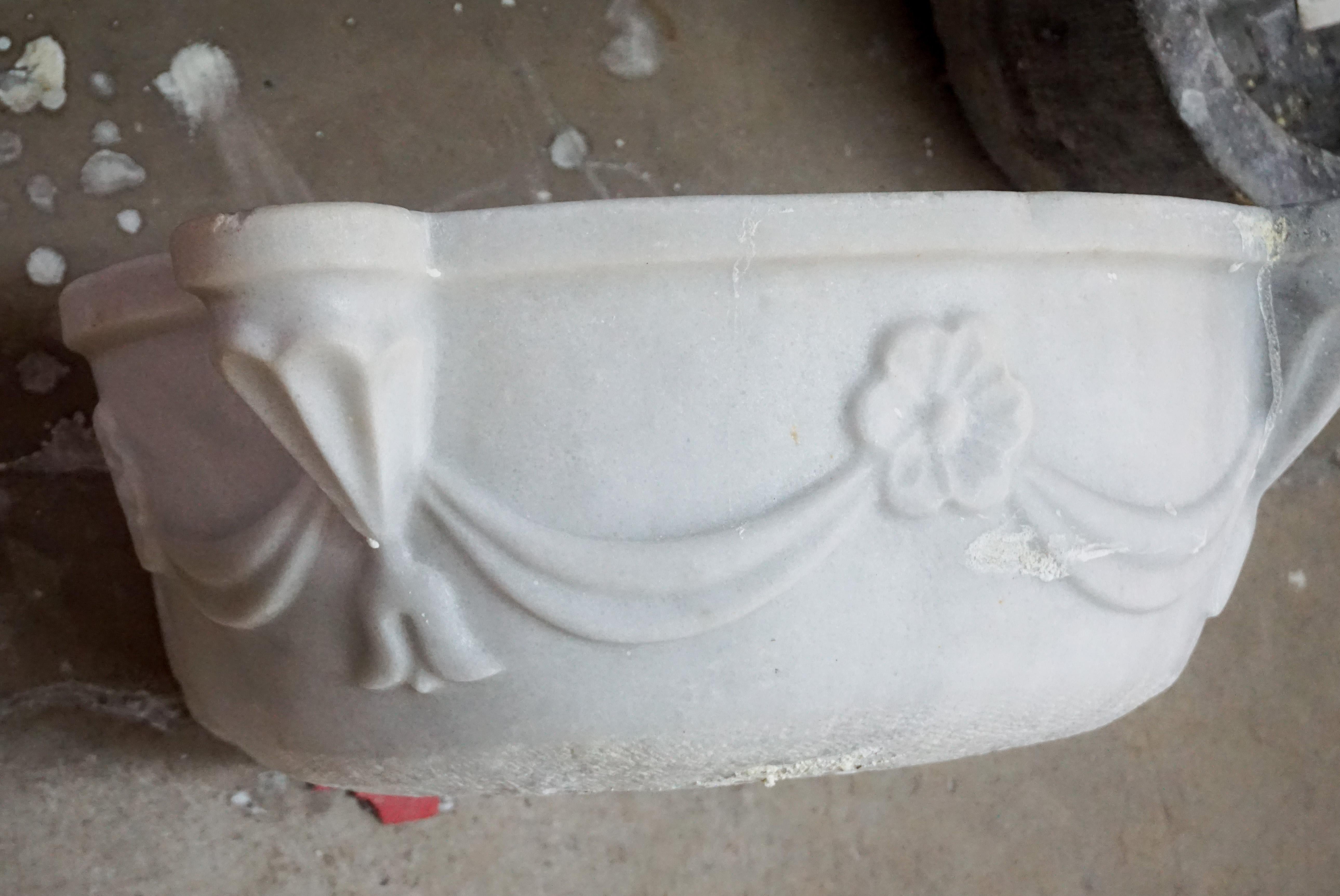 Antique white marble sink with a swag and floral design, circa 1850.