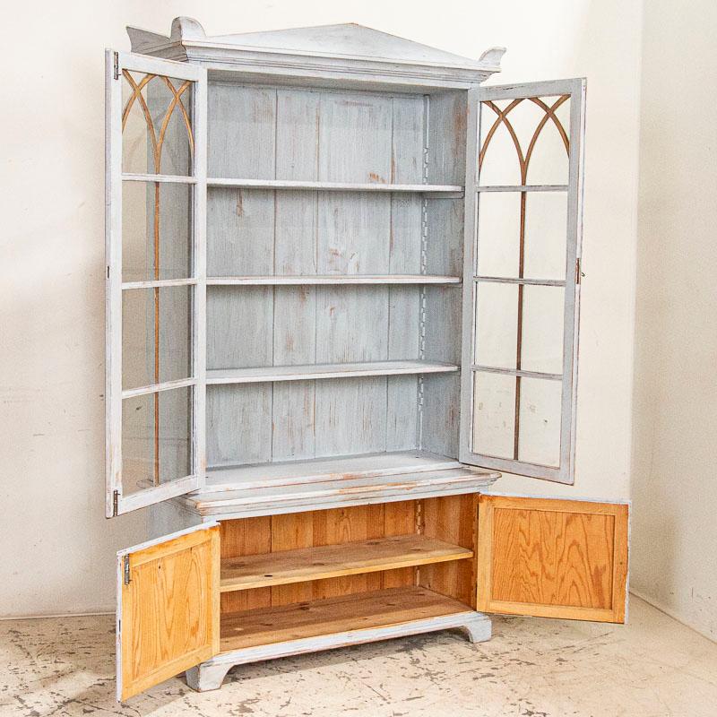 This charming bookcase has lovely lines, especially the delicate gothic trim that accents the long glass display doors. Whether to show off china, collectibles or your book collection, this cabinet will display them well and your arrangement can be