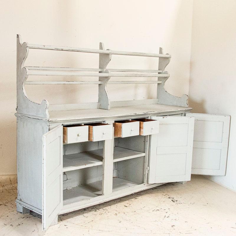 What a fun find! This large Gustavian sideboard originally served in a large kitchen, likely in a Swedish country manor house. Each of the 3 doors opens to reveal two upper drawers and a central shelf. The upper rack is used to display dishes and