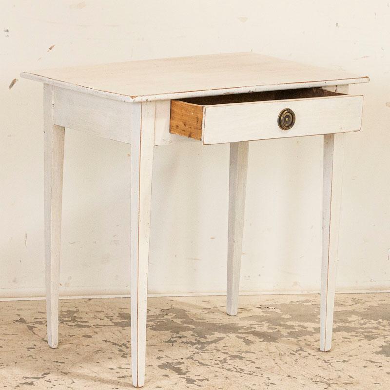 Simple and sweet, the clean tapered legs on this Gustavian style side table create a lovely sense of balance. The white paint is old but not original, while the edges are gently distressed complimenting the age and character of this charming side