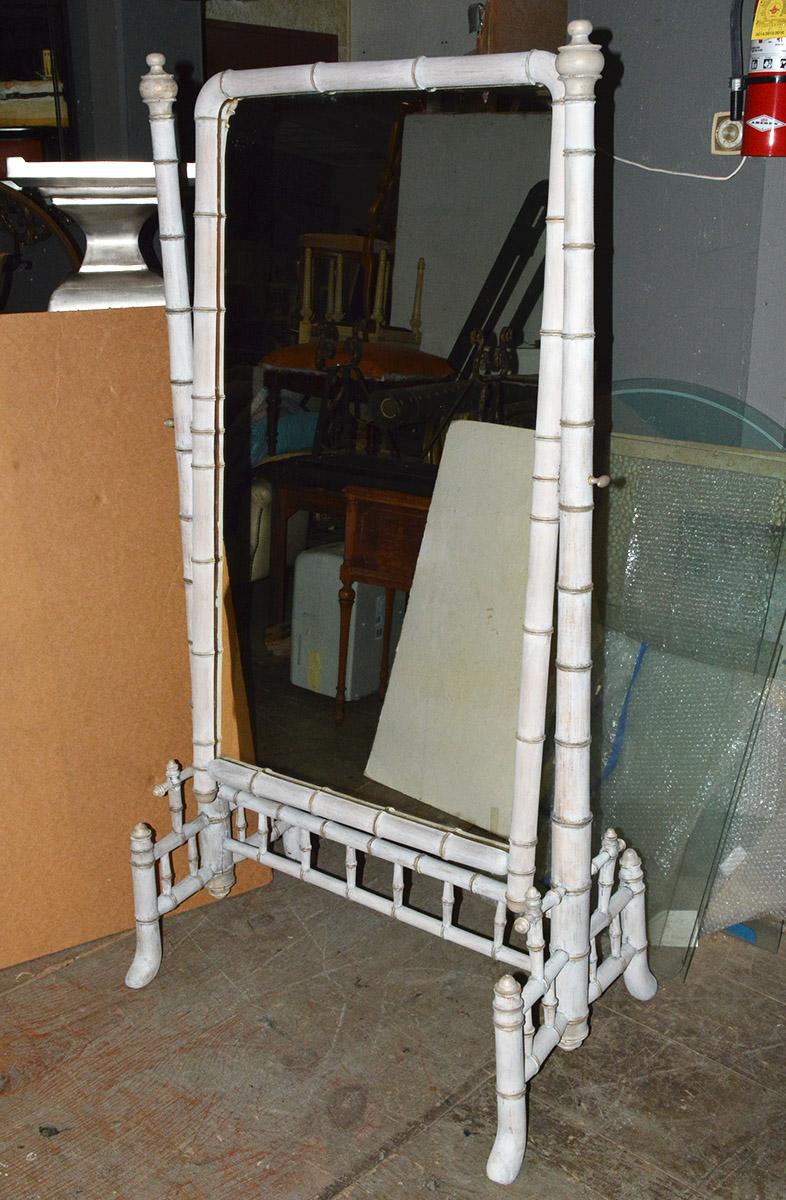 French freestanding cheval mirror, late 19th century. Walnut wood has been turned and white washed to resemble faux bamboo, the posts are capped with baluster finials. Featuring a full length central mirror attached to lateral supports allowing it