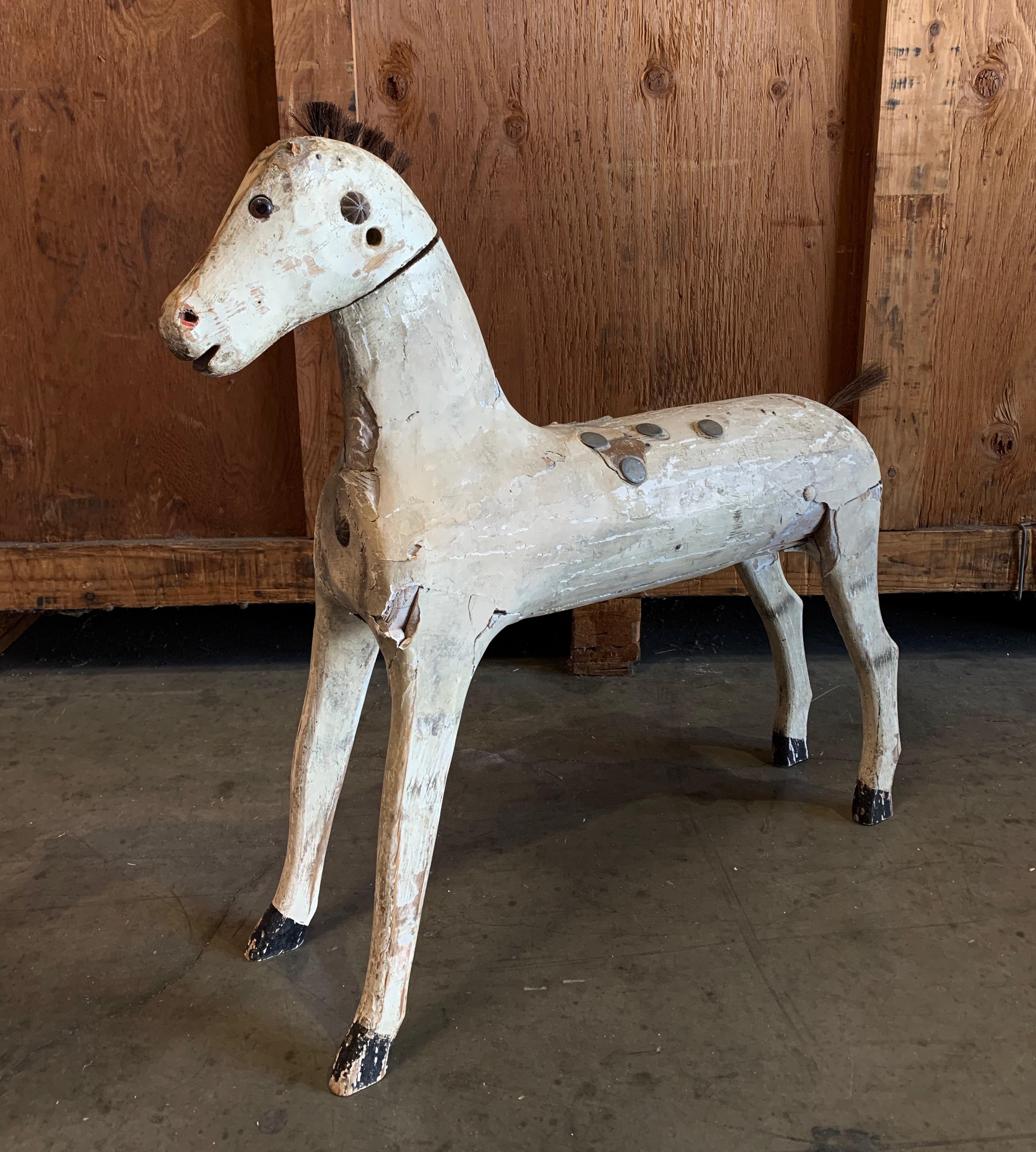 Whimsical Antique white wooden horse acts as an attractive conversation piece on large entry table or stand alone accessory.