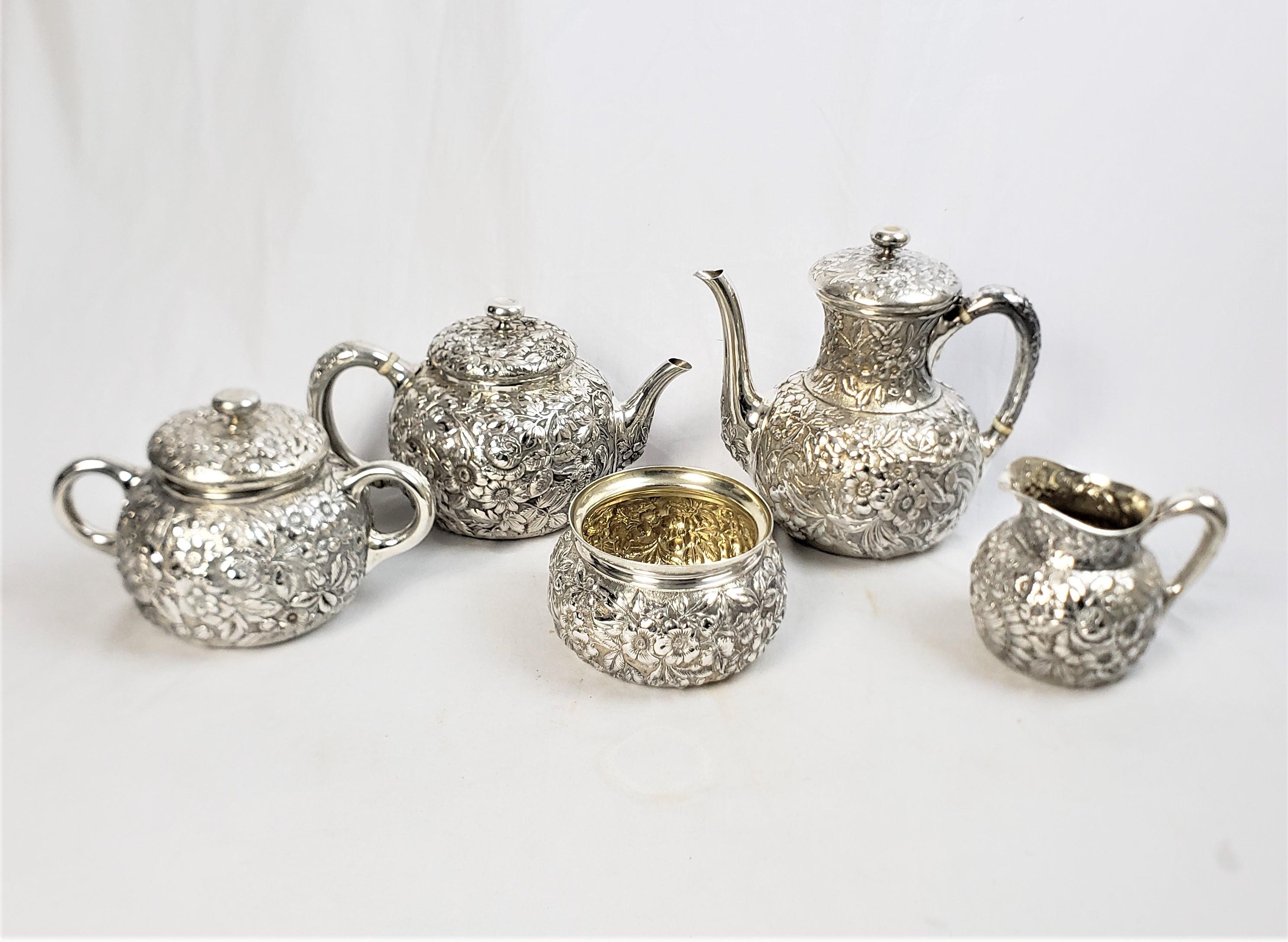 This antique five piece tea set was made by Whiting & Co. of the United States and dates to approximately 1900 and done in a period Victorian style. The set is composed of sterling silver and is done in their signature 