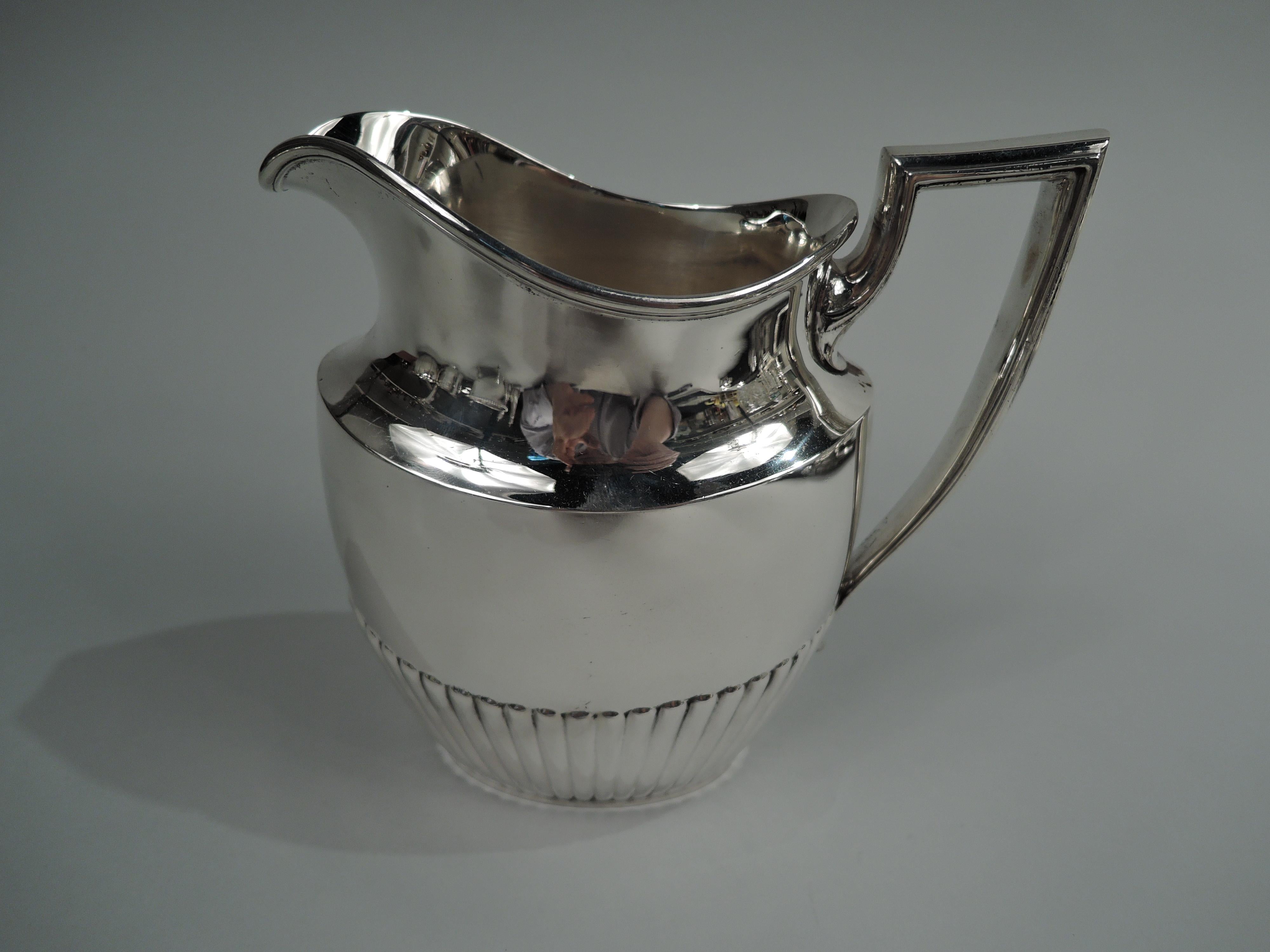 Edwardian Classical sterling silver creamer. Made by Whiting Manufacturing Co. in New York, ca 1910. Ovoid with helmet mouth and scroll bracket handle. Half gadrooning. Fully marked including maker’s stamp and no. 5014, letters SML, and volume (2