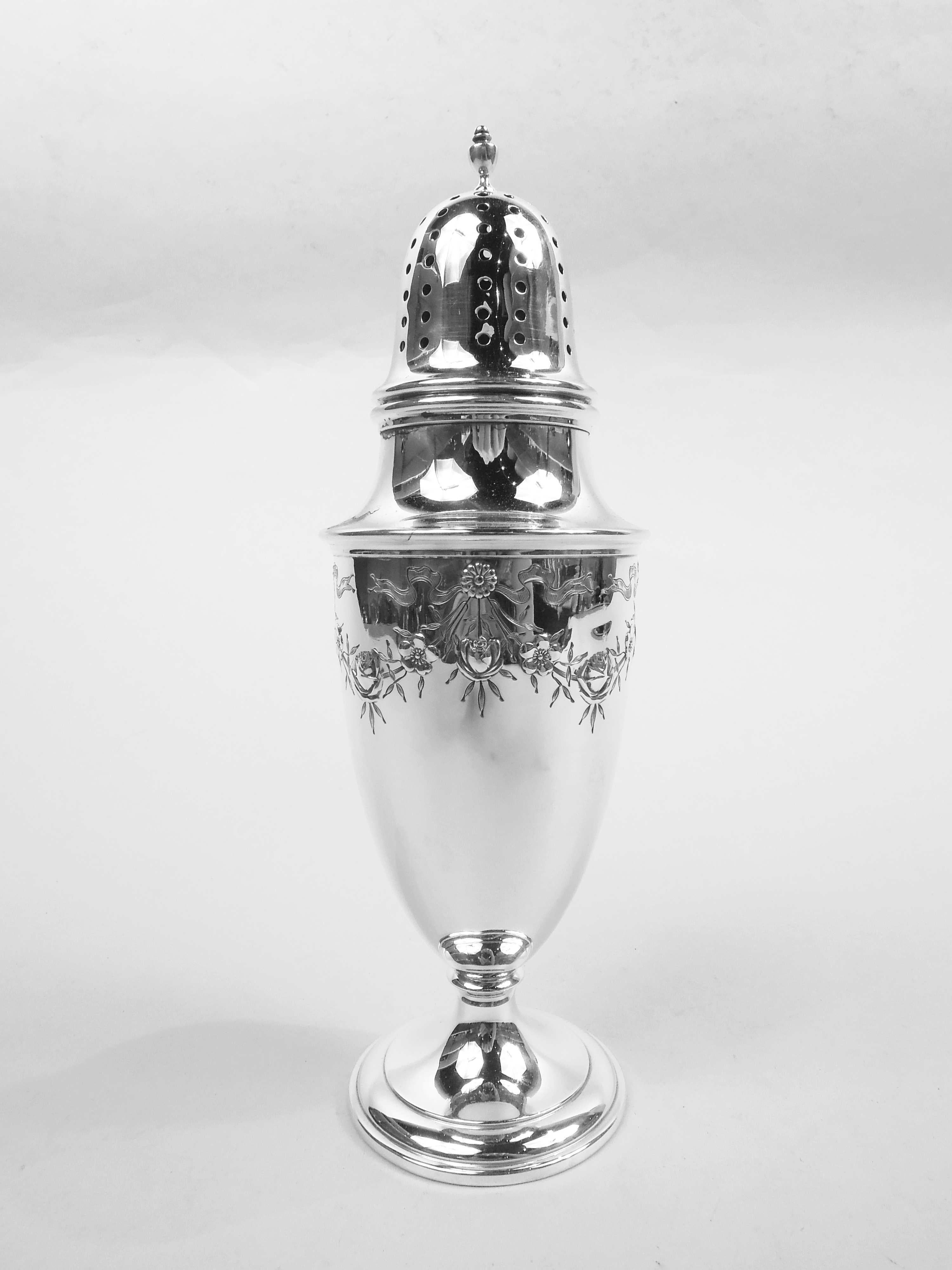 Edwardian Regency sterling silver sugar caster. Made by Whiting Manufacturing Co. in 1917. Ovoid bowl on stepped and raised foot. Cover domed and pierced with vasiform finial. Engraved and chased ribboned paterae with pendant garland. Fully marked