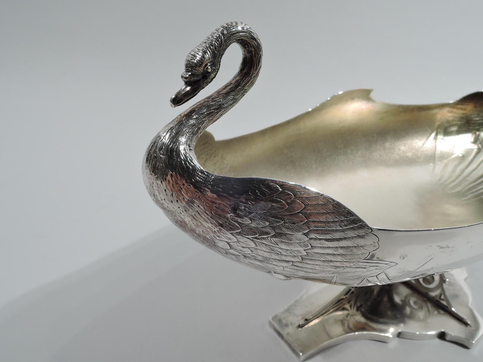 Turn-of-the-century sterling silver bowl. Made by Whiting in New York. Narrow and oval with swan-form ends: head and neck flowing into splayed and engraved wings. Underside has chased Japonesque cattails with turned-down and overlapping tendrils.