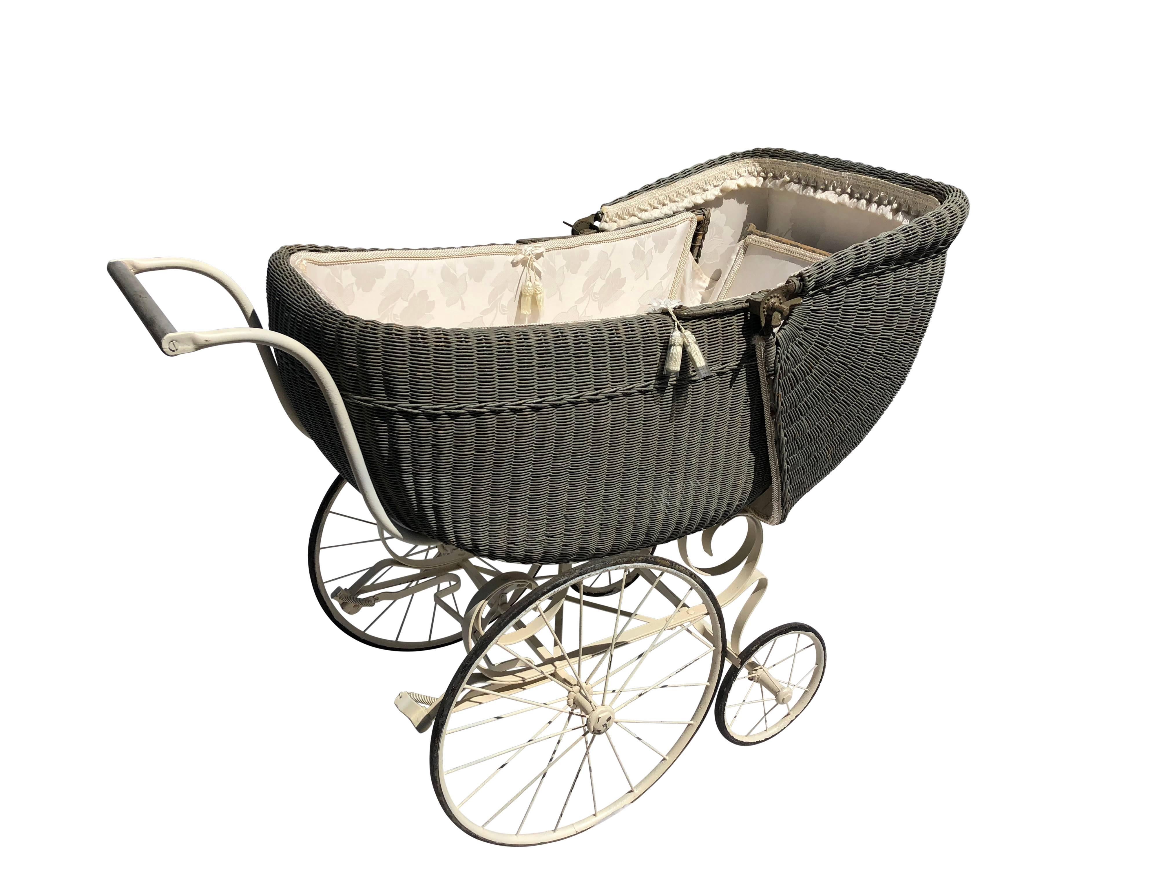 This is an amazing ready to use antique wicker baby carriage in its original color with spring suspension and it's original wheels. The inside top area folds down flat for when the baby is sleeping and can be easily adjusted for a more reclined