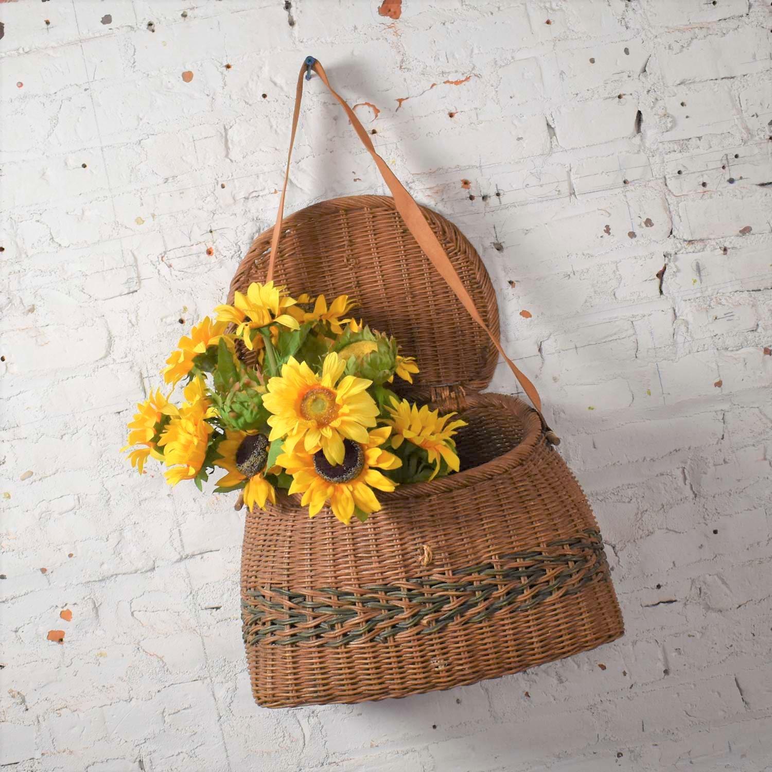 Fascinating antique wicker basket fishing creel with a leather strap handle. It is in wonderful vintage condition. We have not found any breaks in the wicker; however, there is no latch to fasten the lid. It has a beautiful age patina. Please see