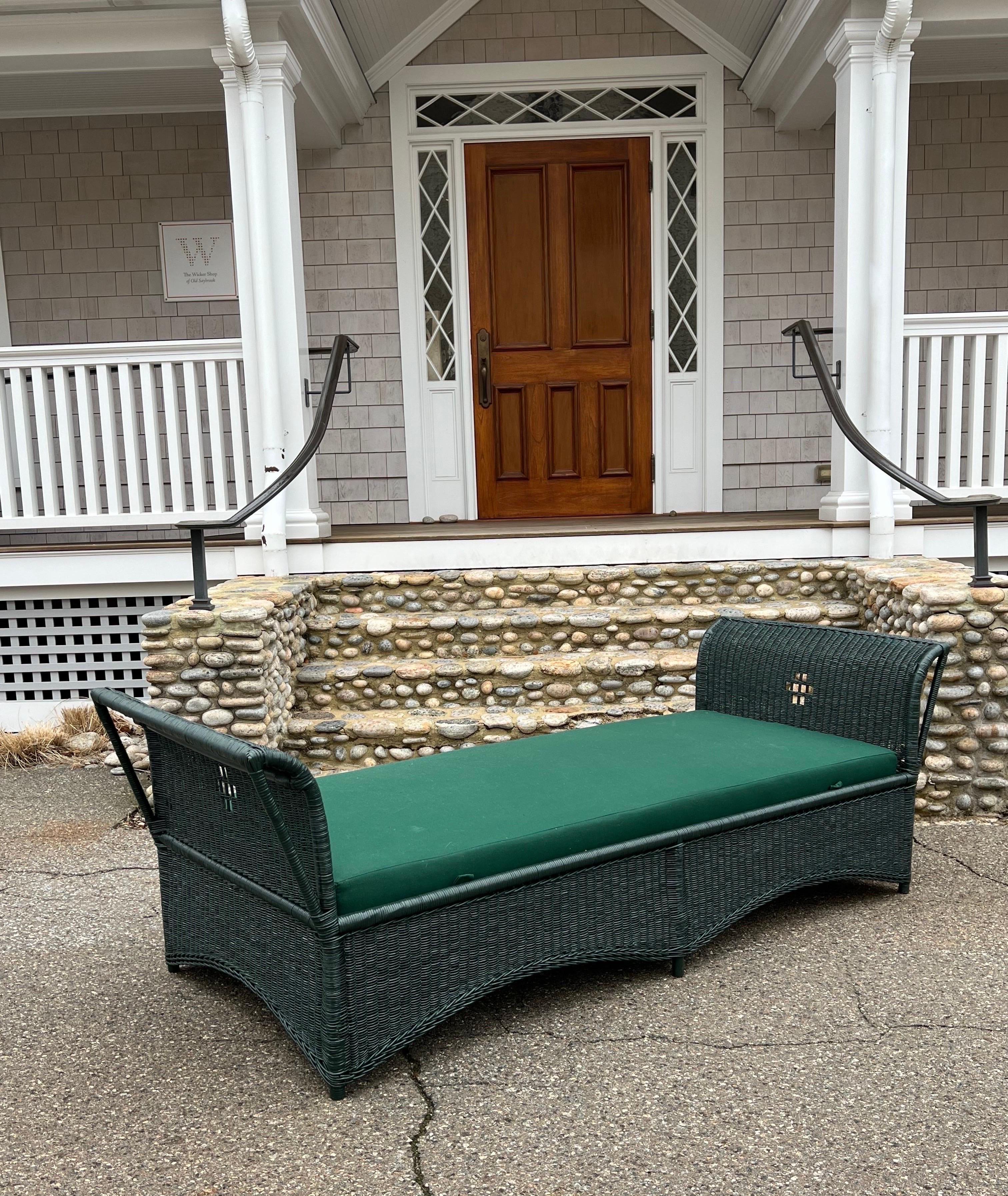 This is an antique wicker daybed woven of reed and painted Benjamin Moore Essex Green. The tied spring mattress sits on a wooden frame and has been freshly recovered. The overall length of this piece is 86” and width is 33”. The mattress measures