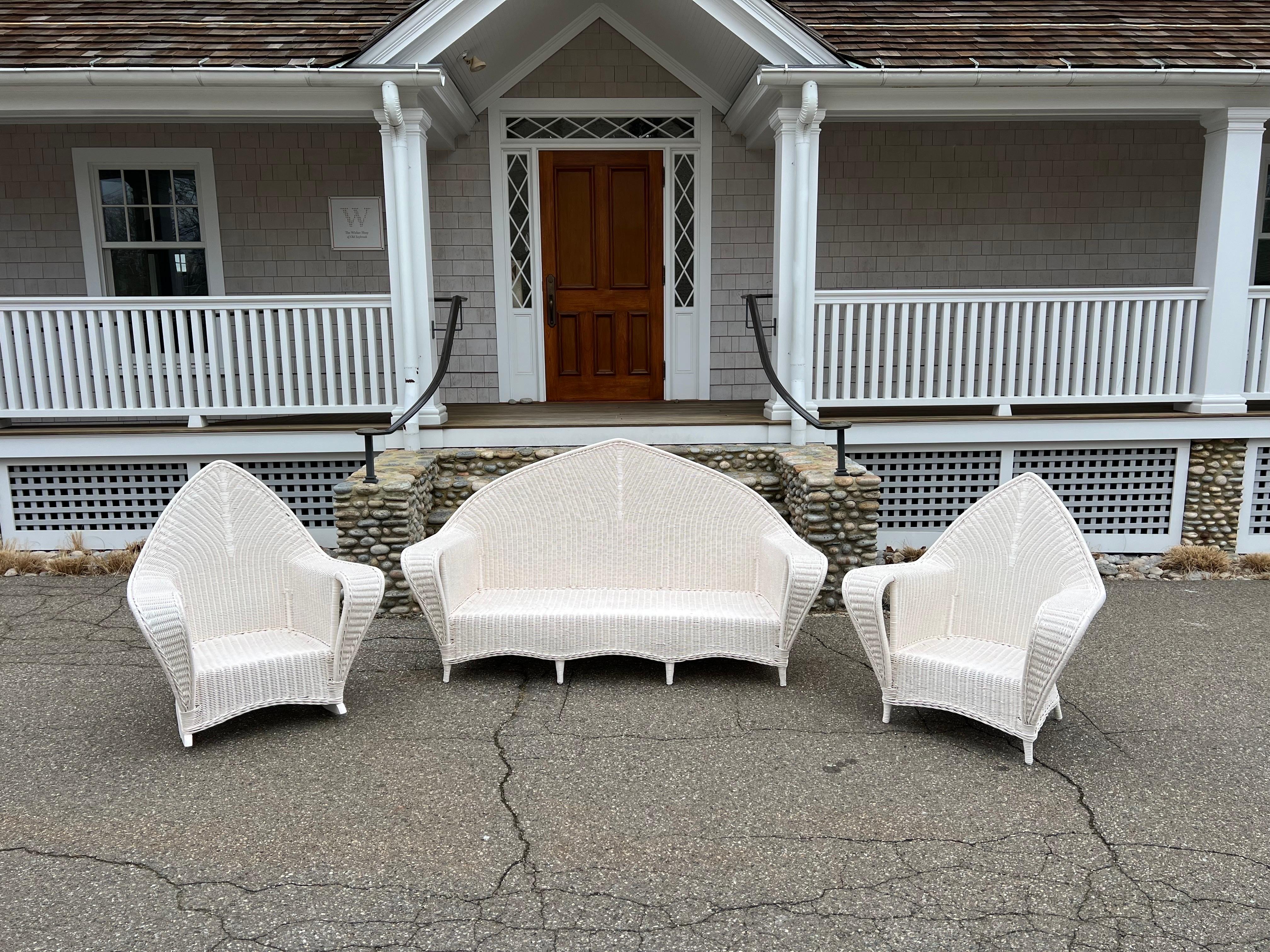 Three piece antique wicker set woven of reed and freshly painted white. Sofa measures 76” wide, 34” deep, 41.5” tall, seat without cushion is 13”. Chair measures 38” wide, 40.5” tall, 32.5” deep with a seat height without cushion of 13”. Rocker