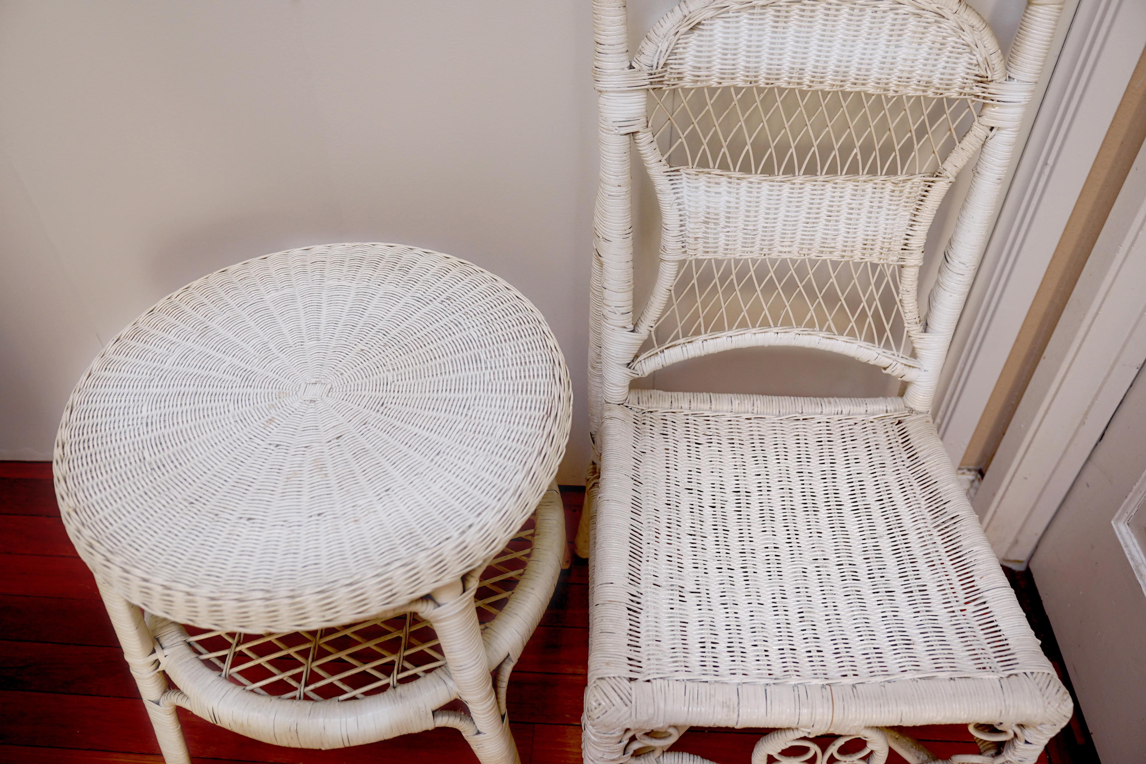 White wicker and rattan make a statement  in this pairing of a Victorian style wicker chair and a side table. The chair is antique and the craftsmanship is beautiful. 