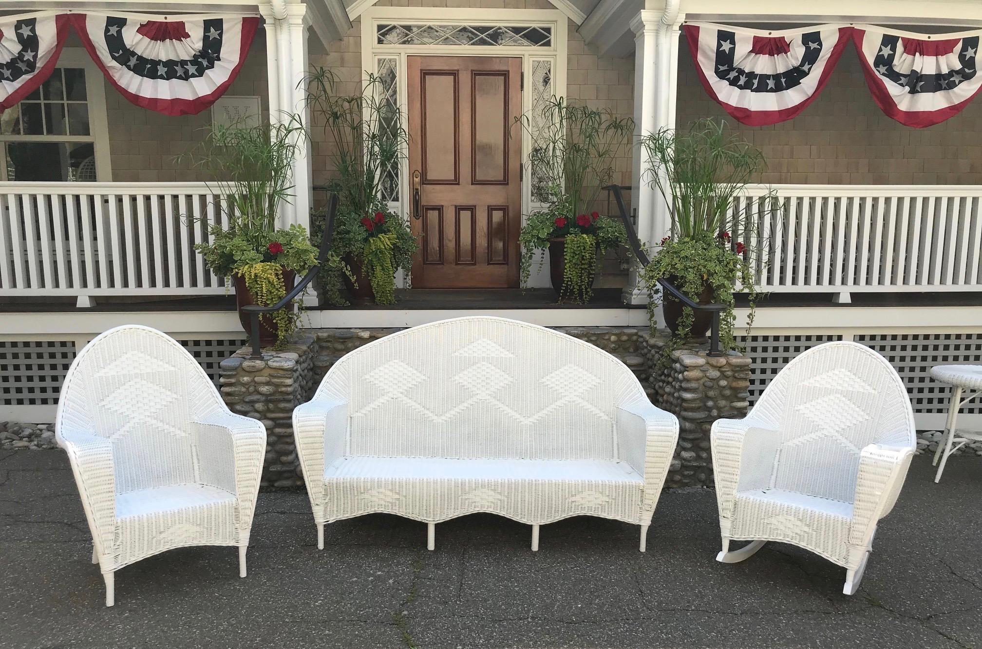 Antique wicker porch set woven of reed. Sofa, chair, rocker and sofa table freshly painted white. Beautiful design and scale. Sofa measures 72