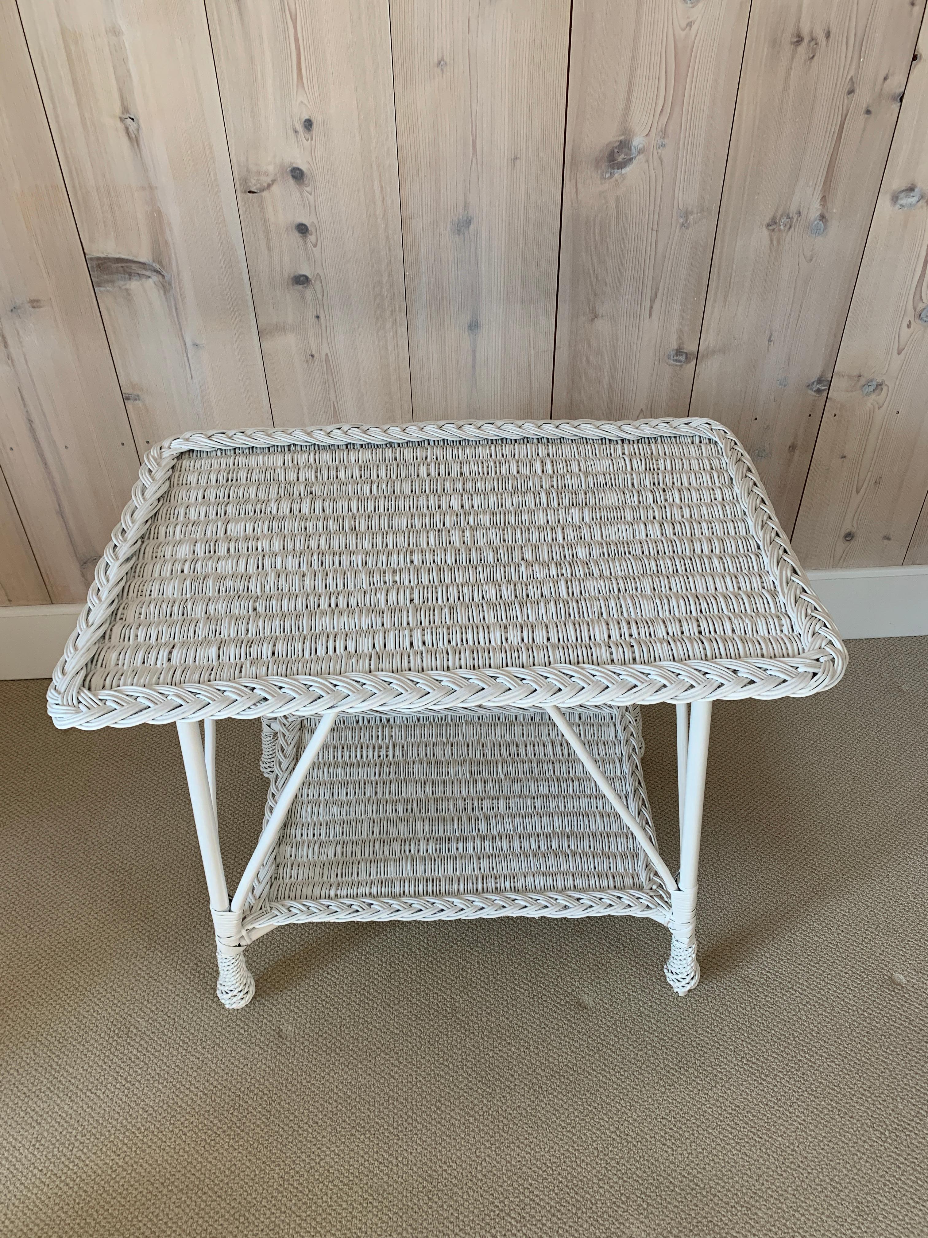 Antique Willow table in white paint. Woven top and lower shelf. and pineapple feet. Table measures 37