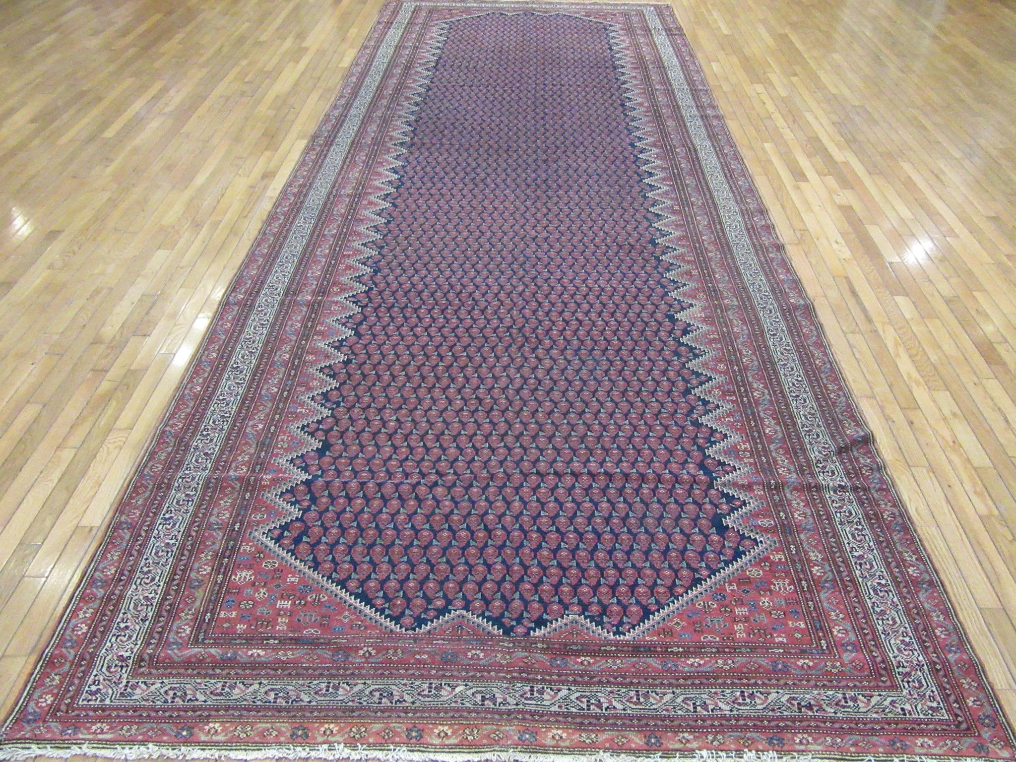 This is an antique hand knotted wool gallery size rug made with wool colored with natural dyes. It has a small scale repetitive all-over pattern on a navy blue background, The rug measures 6' 7'' x 26' 8''
circa 1900.