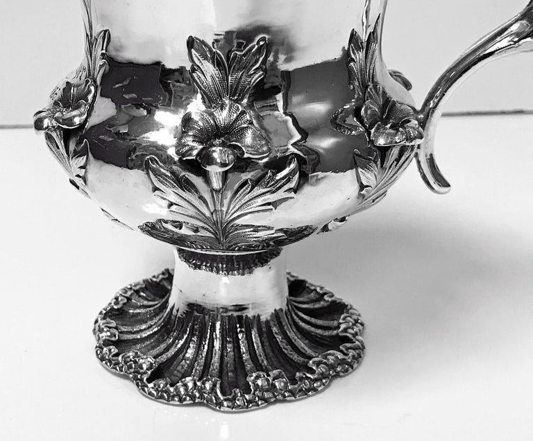 Antique William IV sterling silver large christening mug, London, 1834, Jonathan Hayne. The mug of campana shape on rocaille shell textured scalloped pedestal base, repousee body with shell and rosette decoration, centering elaborate cartouche with