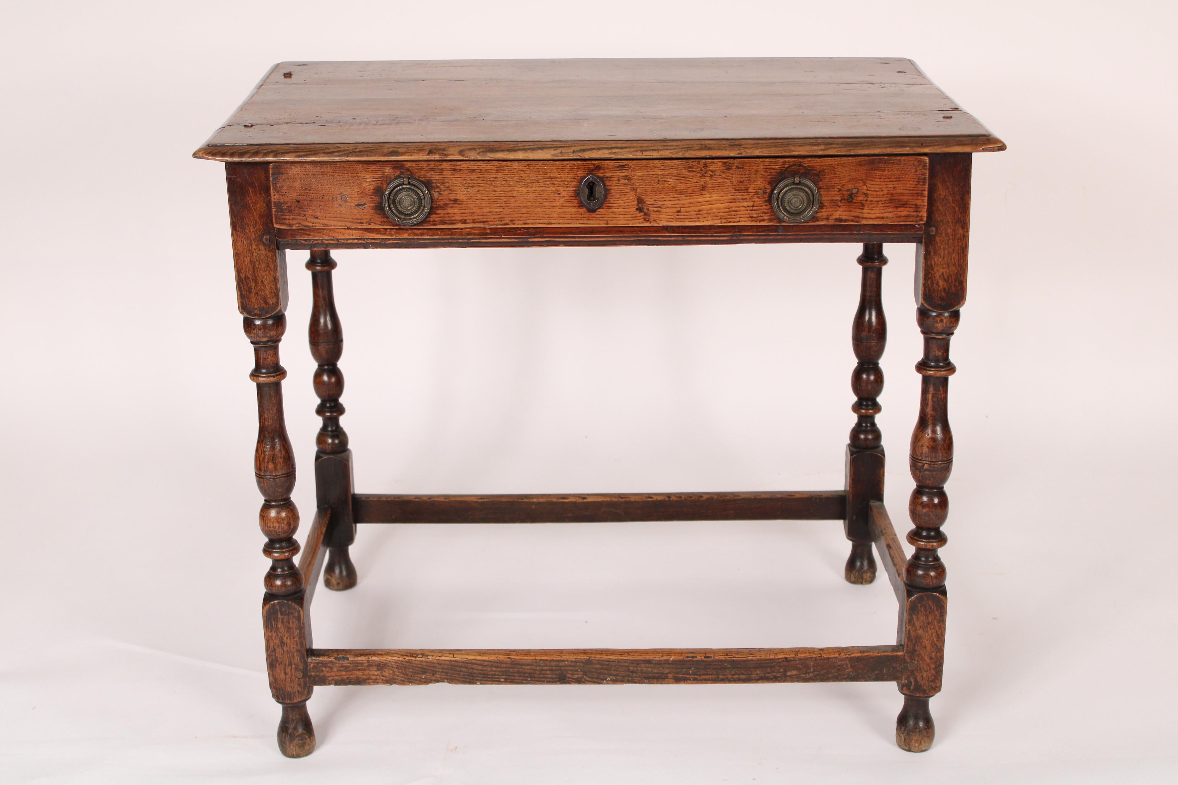 Antique William and Mary style oak tavern table, 19th century. With a rectangular over hanging top with thumb molded edges, turned legs joined by stretcher bars.  The oak has a nice old color. Mortise, tenon and peg joinery.