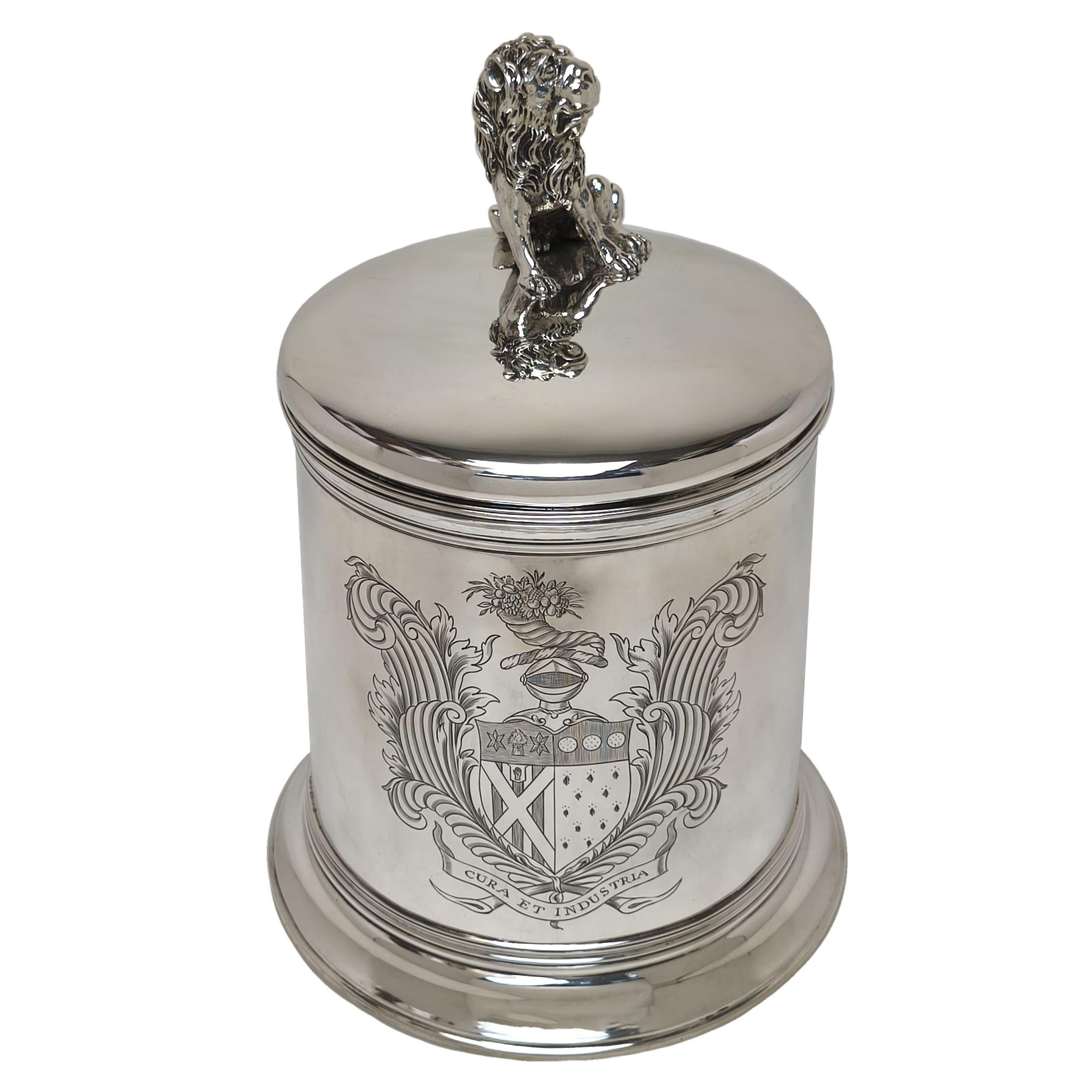 An impressive Antique Sterling Silver Lidded Tankard made in the early 20th century in the style of a William III 17th Century Tankard. This enormous Tankard has a large Lion on the lid and features a magnificent armorial engraved opposite the