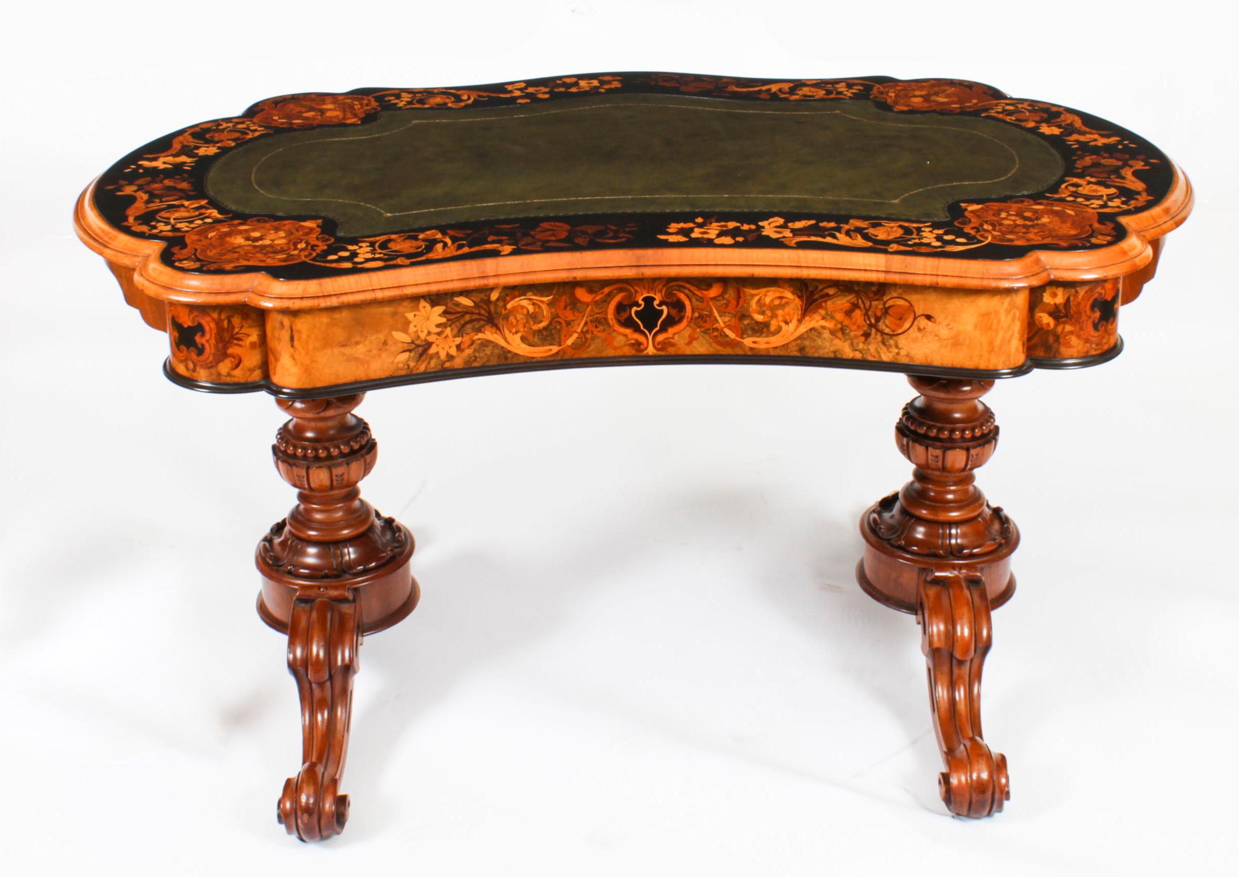 A beautiful antique William IV burr walnut, ebony, ebonized and marquetry kidney shaped writing table, circa 1835 in date.
 
The shaped top features an inset gilt tooled green leather writing surface within an ebonized border with floral marquetry